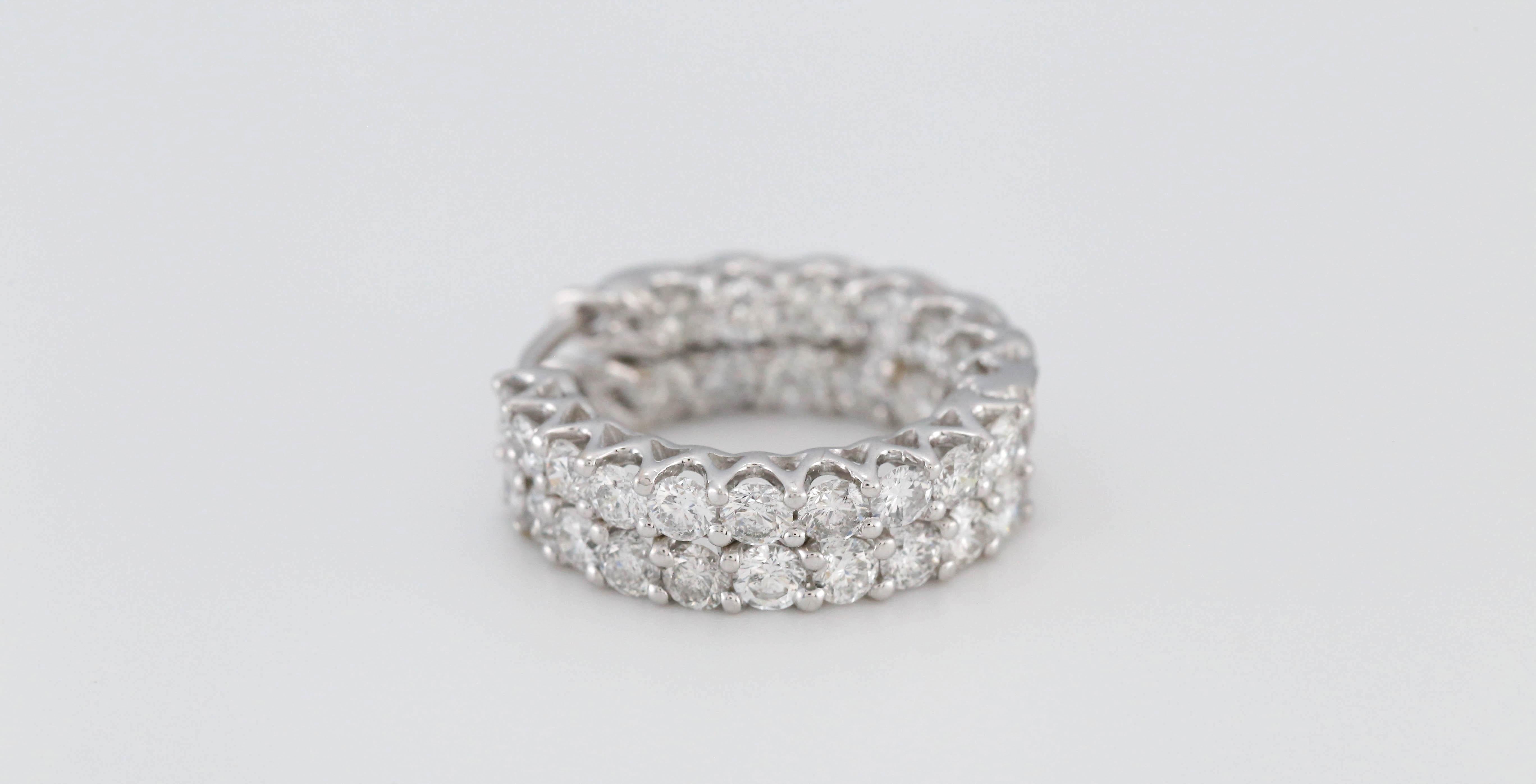 These elegant 14k white gold hoop earrings are adorned with two rows of brilliant round diamonds in a full eternity design. Each diamond is expertly prong-set, maximizing sparkle and creating a continuous shimmer from every angle. The interior and