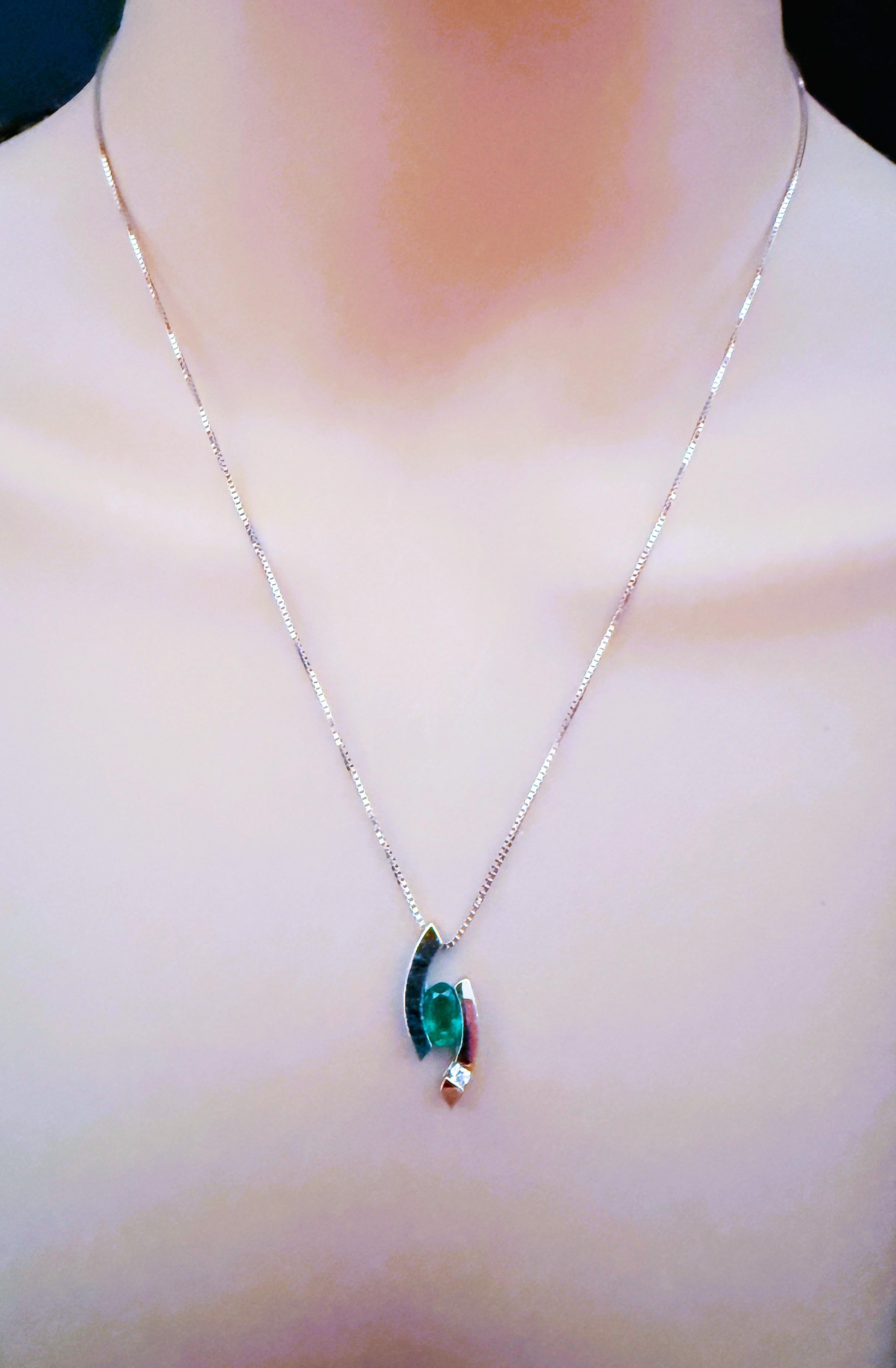 What a beautiful necklace!  There is a 6.5 carat emerald center stone measuring 6.5 x 4.5 mm. and there is also a .03 carat brilliant cut diamond on this beautiful 14k white gold setting.  It's a very modern look.  The pendant itself is 20.7 mm long