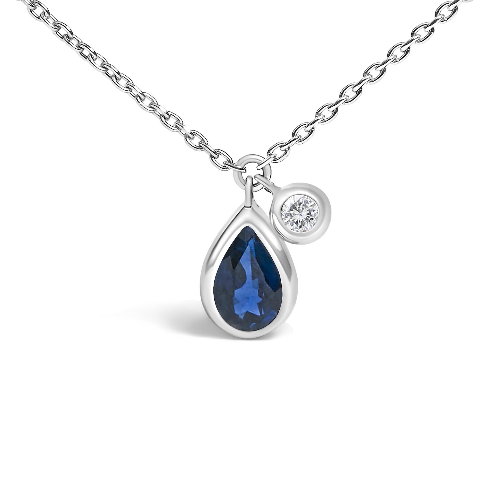 Emanate elegance with a pendant that combines celestial charm and artisanal craftsmanship. Nestled in the heart of this dazzling adornment lies a natural, heat-treated pear-shaped blue sapphire, its mesmerizing hues reminiscent of twilight skies.