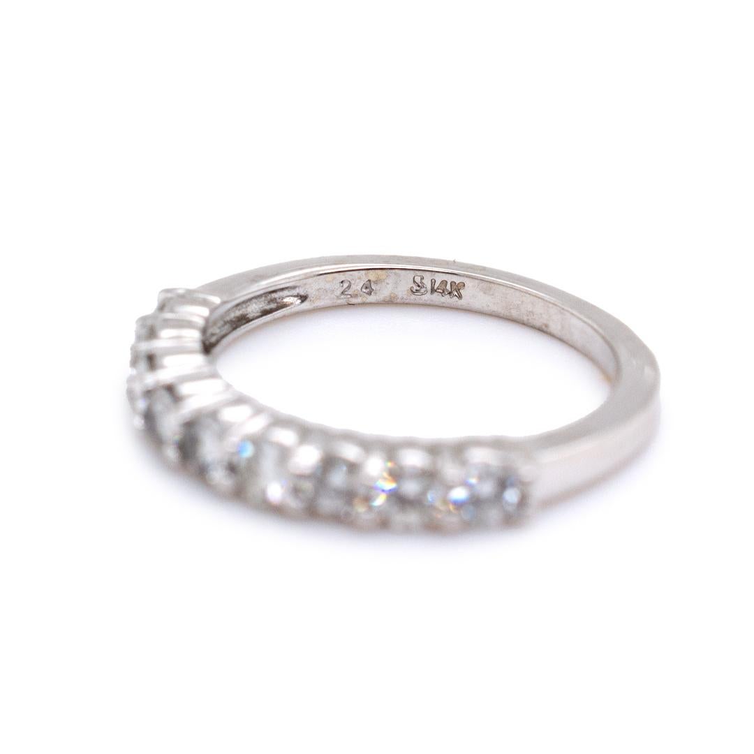 One ladies custom made polished 14K white gold nine-across, diamond eternity ring with a soft-square shank. The ring is a size 4.50, is 1.44mm thick and measures approximately 1.93mm tapering to 1.60mm in width and weighs a total of 2.20 grams.