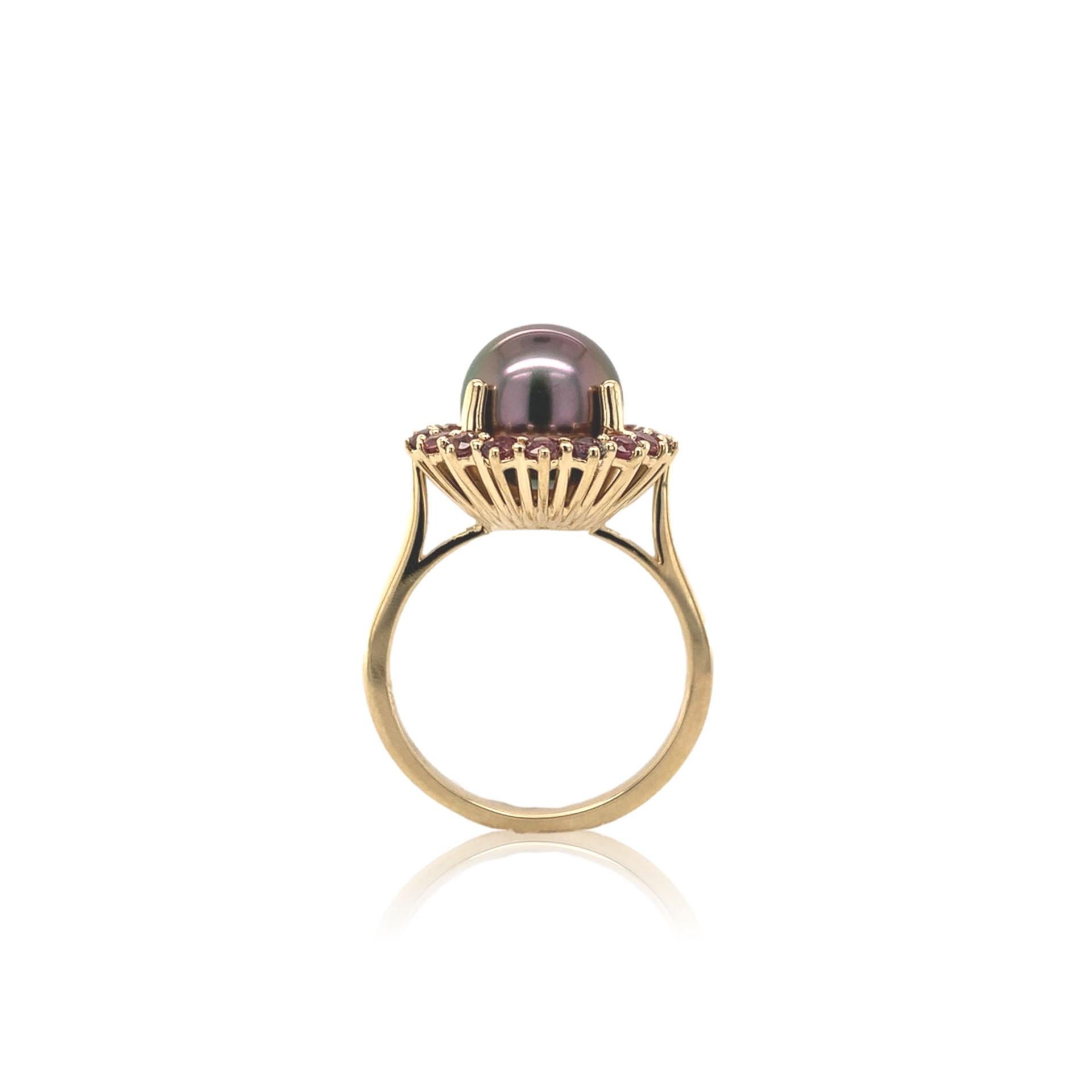 14K white gold ring featuring a 9.5mm black cultured Tahitian pearl with pinkish-purple sapphire halo. The pearl is a fine quality with peacock and aubergine overtones. It is very clean without blemishes. There are 18 small round brilliant cut 2mm