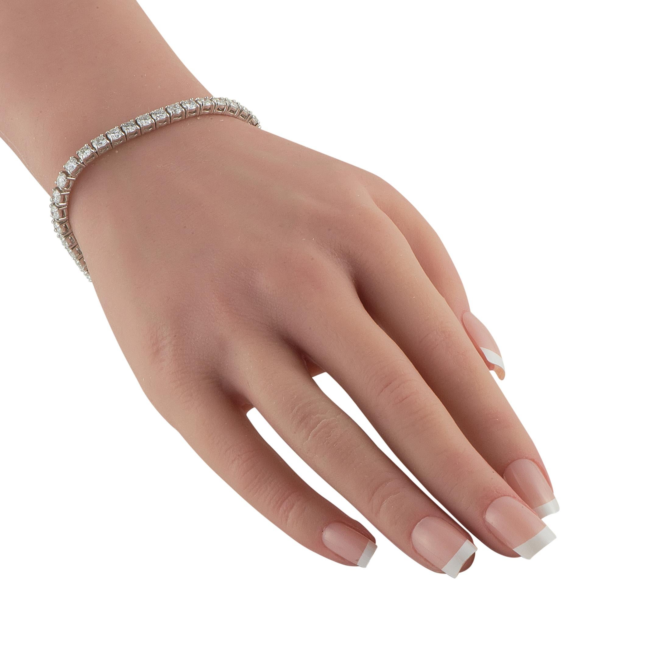 A white gold bracelet gleaming with 9.80 carats of carefully selected diamonds. This piece showcases a clean, continuous line of glitter that creates a fluid, elegant movement around the wrist. The secure box clasp ensures it stays in place, while