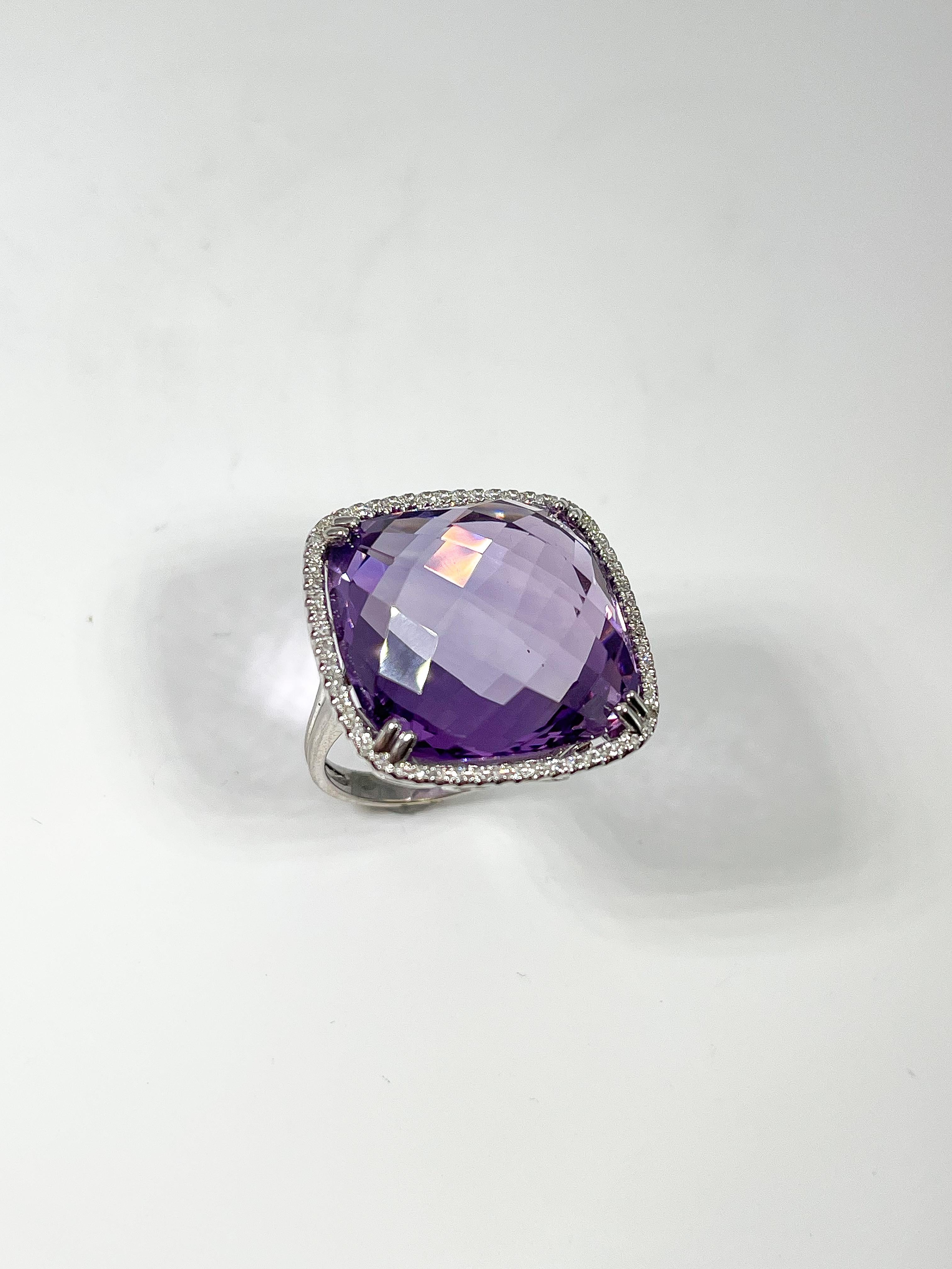 14k white gold cushion cut amethyst and diamond 1 CTW halo fashion ring. Ring has a split shank and scrolling detail on the under gallery. Amethyst measures 19.5 x 19.5 mm, ring is a size 6 1/2 and has a weight of 9.6 grams.