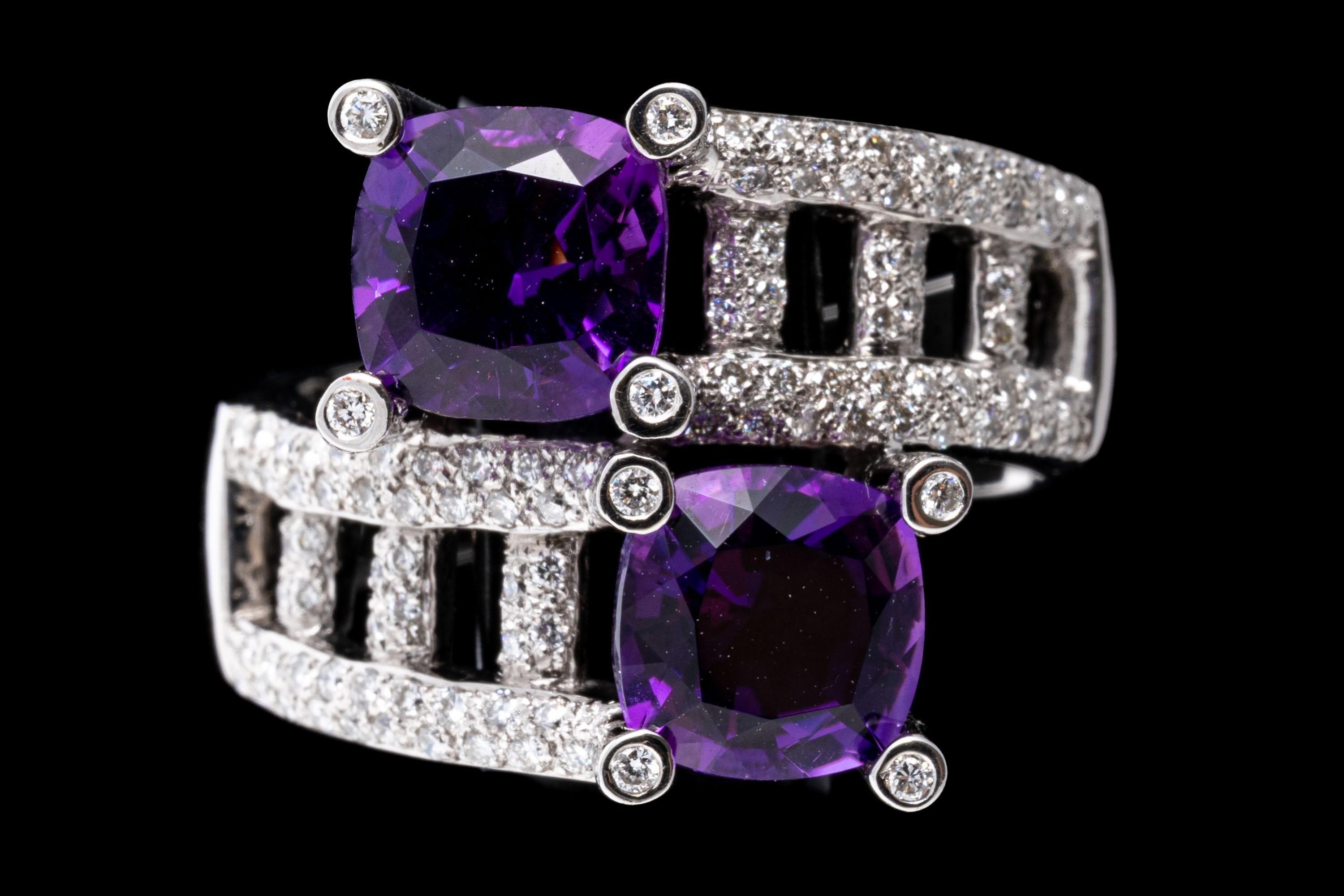 14k white gold ring. This striking bypass style ring is set with two square cushion faceted, dark purple color amethysts, approximately 2.32 TCW, prong set, and decorated with offset, thick ladder style crossover shoulders, pave set with round