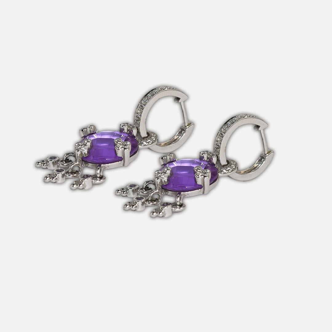 Ladies' dangle earrings with diamonds and amethyst in 14k white gold settings.
Stamped 585 and weighs 12.7 grams gross weight.
The amethyst are round cuts with fancy checkerboard faceting, approximately 11.00 carats total weight.
The diamonds are