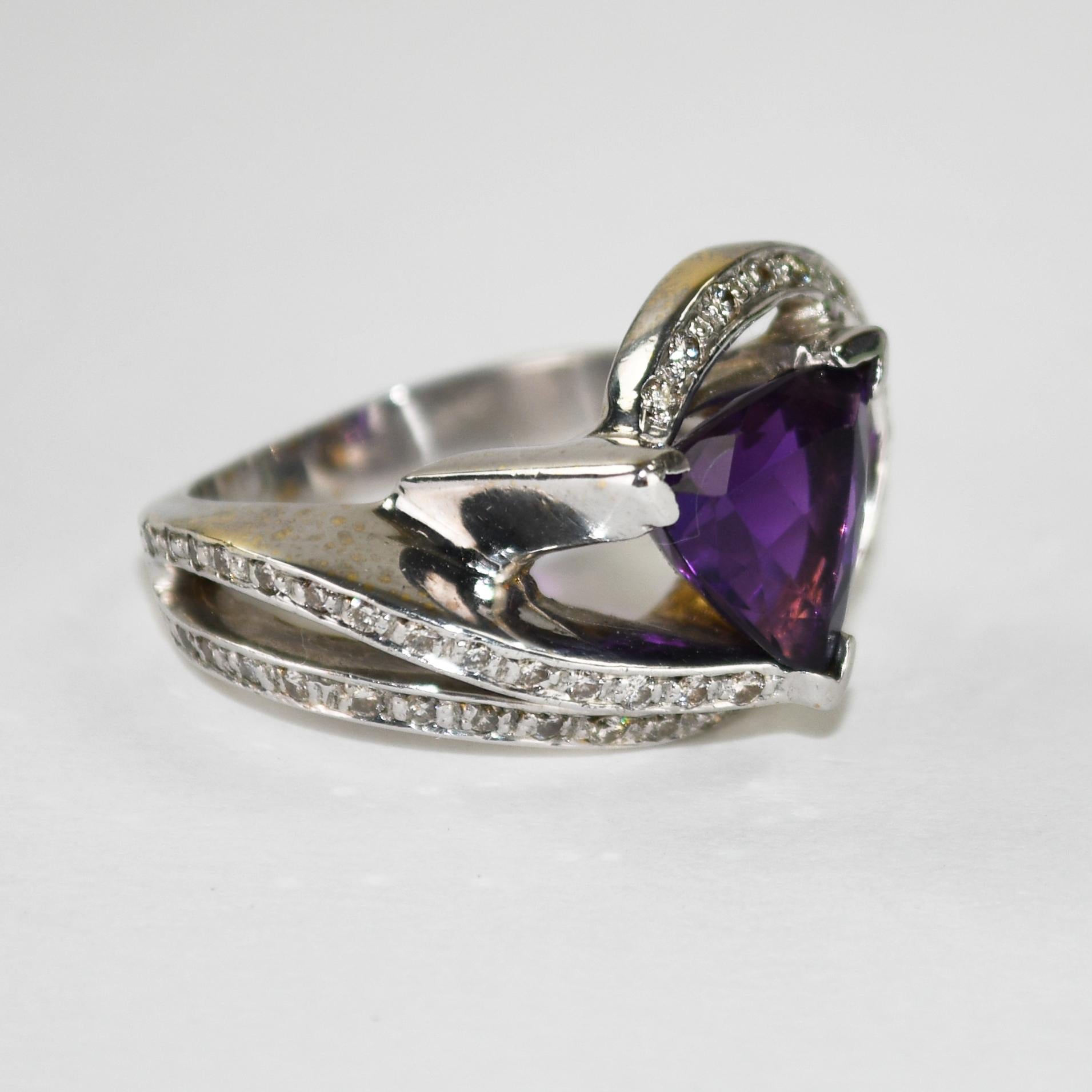 Anello da donna personalizzato con ametista e diamante e montatura in oro bianco 14k.
Timbrato 14k e pesa 14,3 grammi.
L'ametista è a forma di triangolo sfaccettato, 4,50 carati, di grande colore.
Alcune abrasioni sulle giunzioni delle faccette.
I