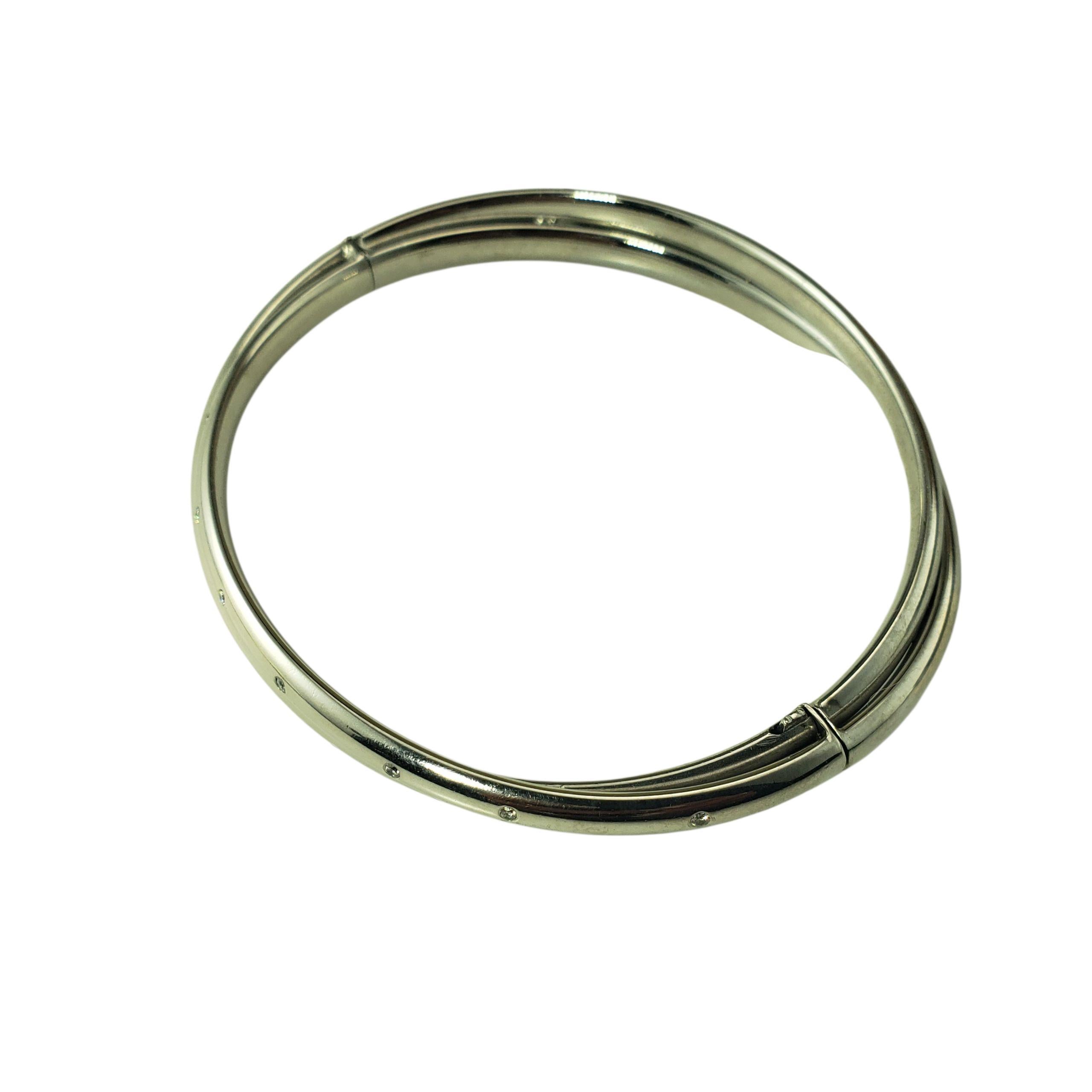 14K White Gold and Diamond Double Bangle Bracelet-

Contemporary and refined, this hinged double bangle bracelet is crafted in 14K white gold and accented with 14 round brilliant cut diamonds spaced along polished surface, adding subtle sparkle from