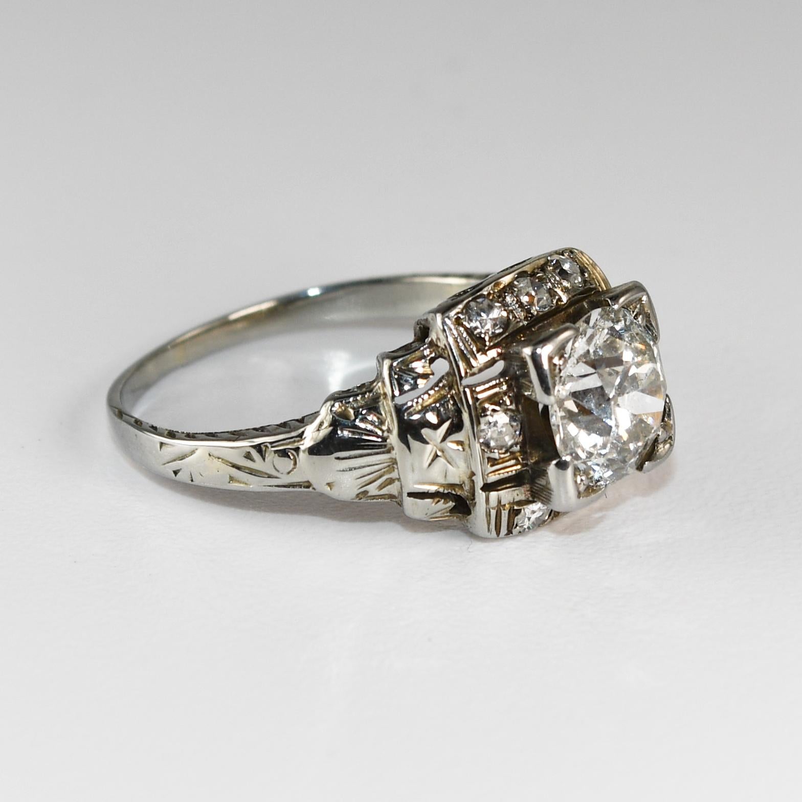 Anillo antiguo de diamantes en oro blanco de 14k.
Prueba 14k y pesa 2,7 gramos.
El diamante central es una talla Euro antigua, de 1,00 quilates, color i a j, claridad i1.
Los diamantes laterales son redondos, talla única, 0,20 quilates en total,