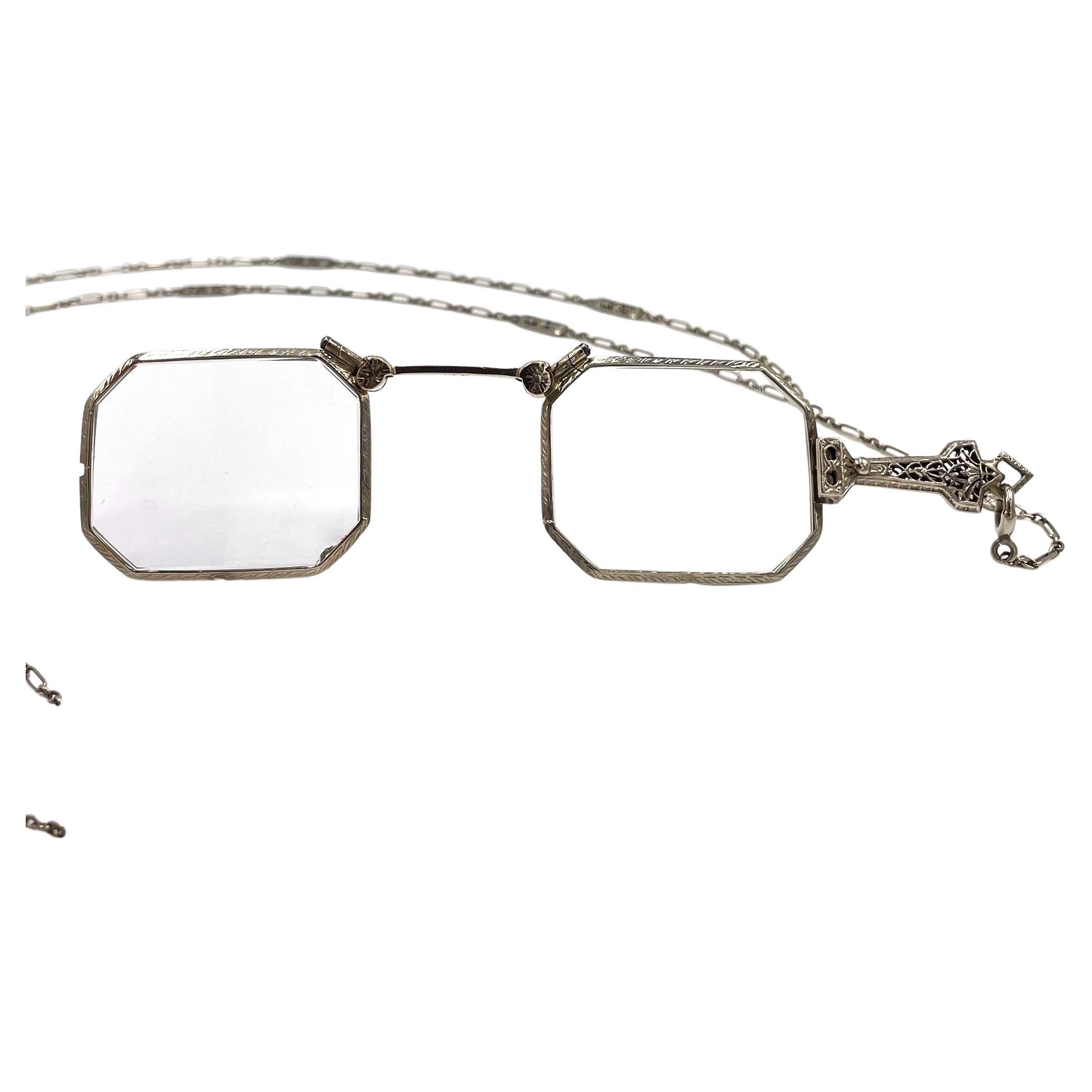 19th Century Antique Victorian folding lorgnette eye glasses.
The lenses are encased in 14k white gold and is hand engraved.  It has a handle and comes with a removable 14k white gold chain larriate.  The 14K white gold fancy square link chain is 30