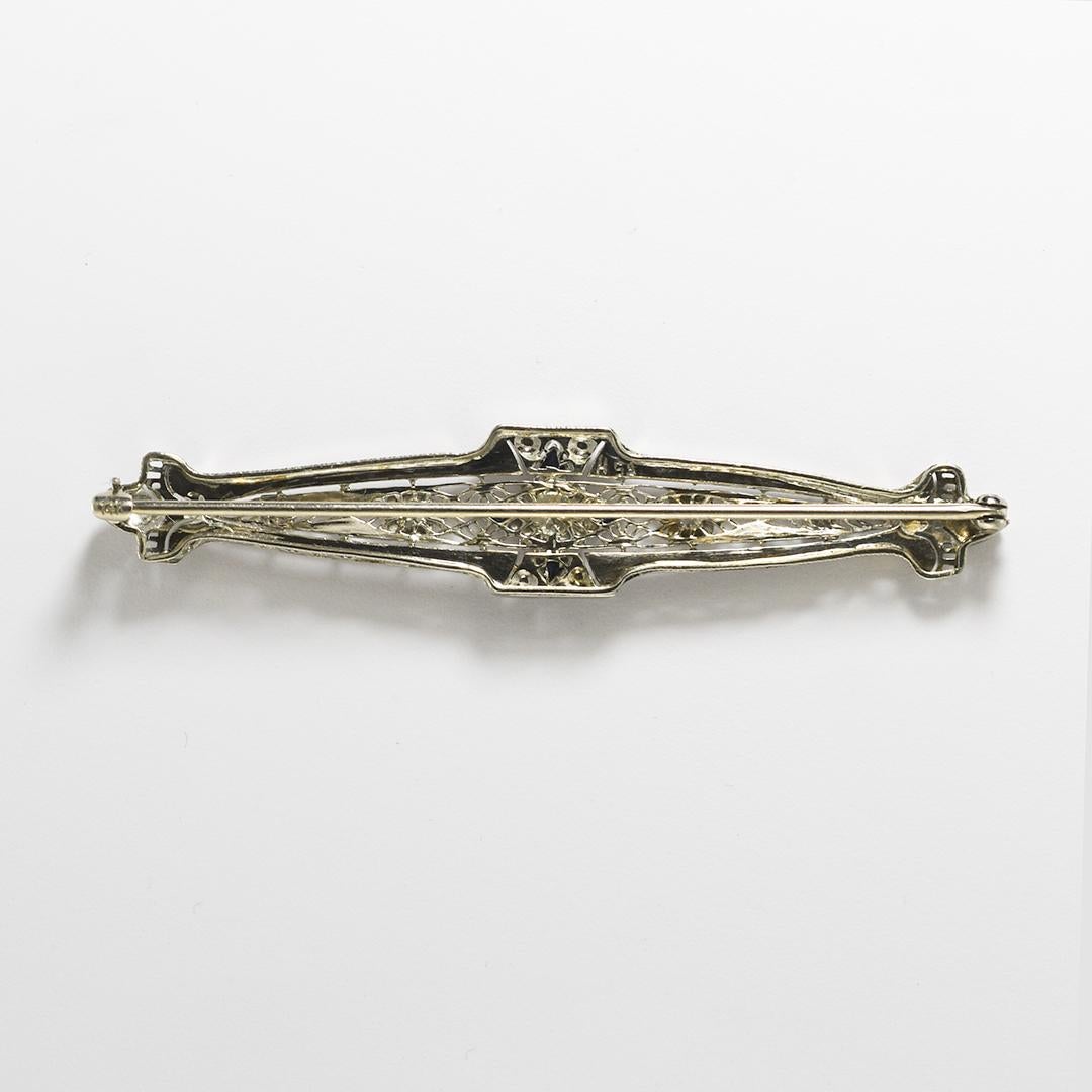 Spilla antica con diamante in oro bianco 14k, art deco.
La cerniera reca il timbro 14k e pesa 6,1 grammi.
Il diamante centrale è un taglio di transizione, di 0,25 carati, di colore I, di purezza vs.
Gli altri diamanti sono di taglio più vecchio,