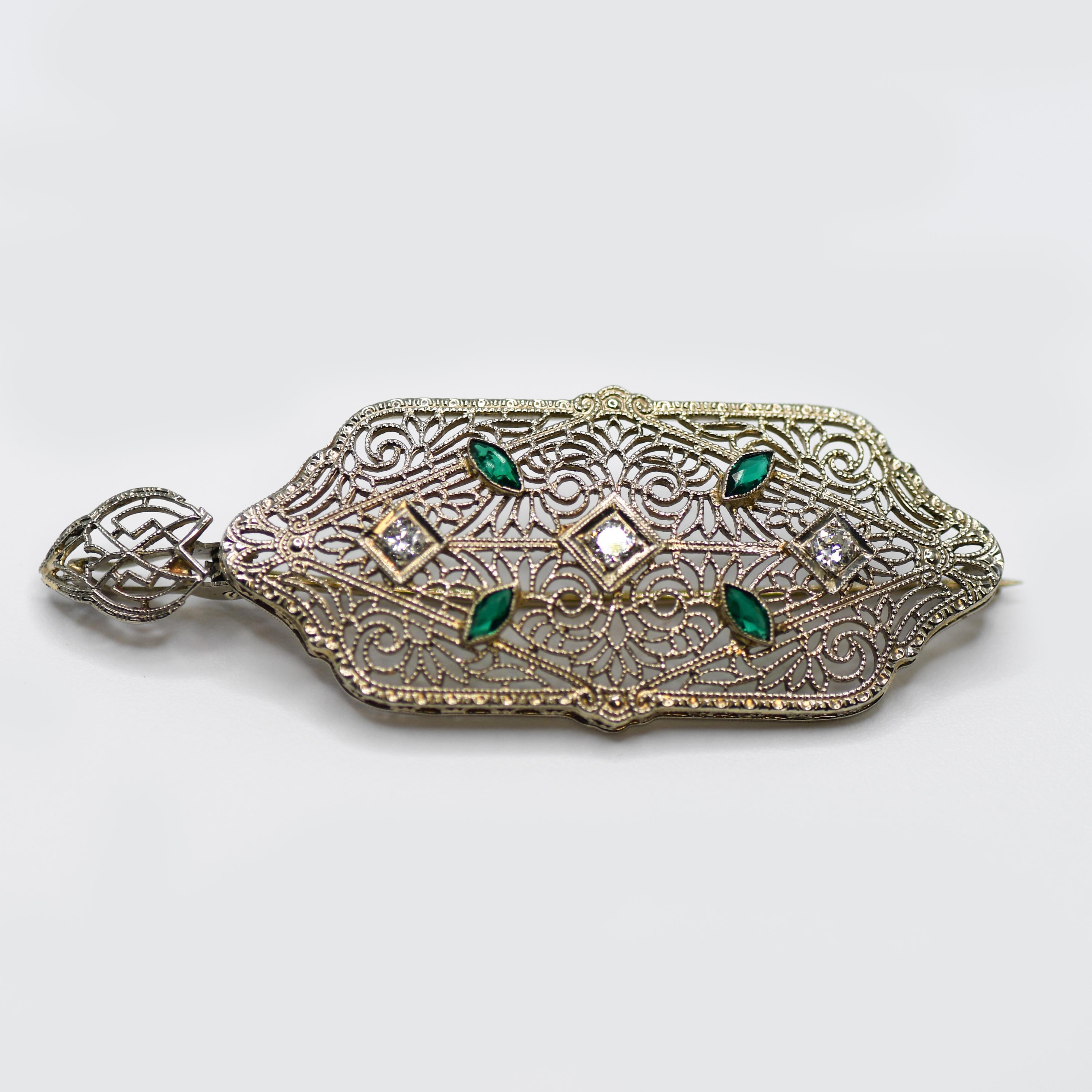 Art Deco brooch and pendant in 14k white gold setting.
Stamped 14k on the hinge and weighs 4.7 grams.
There are three round-transition cut diamonds, .20 total carats, i, j, k color range, Vs to Si clarity.
Also, there are four marquise shape green