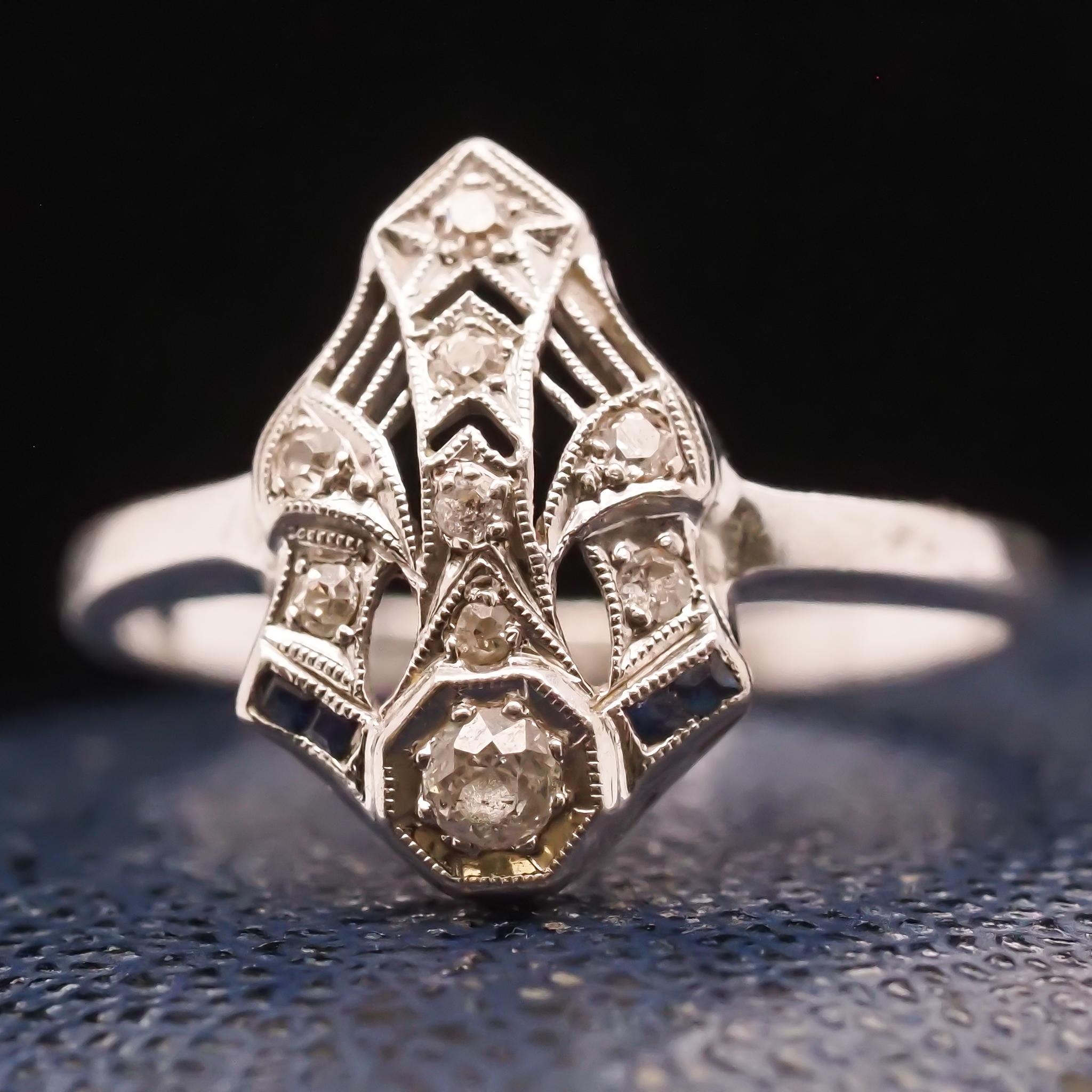 Year: 1940s
Item Details:
Ring Size: 8.25 (Sizable)
Metal Type: 14K White Gold [Hallmarked, and Tested]
Weight: 3.5 grams
Diamond Details: .15ct, Transitional Round, G color, VS Clarity
Sapphire Details: .05ct total weight,
Band Width: