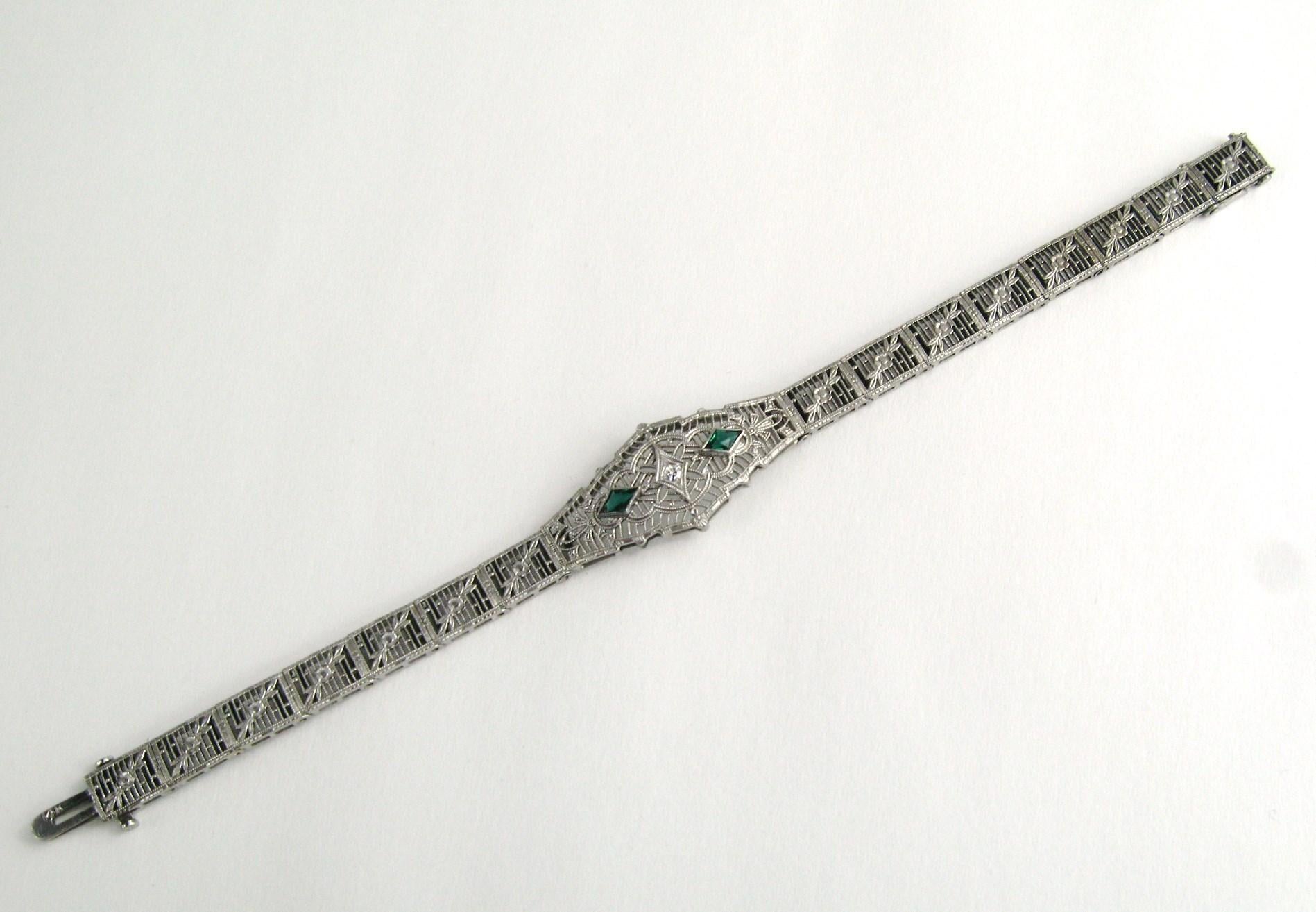 Splendido bracciale Art déco degli anni '20, con pietre di vetro verdi e un accento di diamante al centro. Incastonato in oro bianco 14 carati. Misura .59