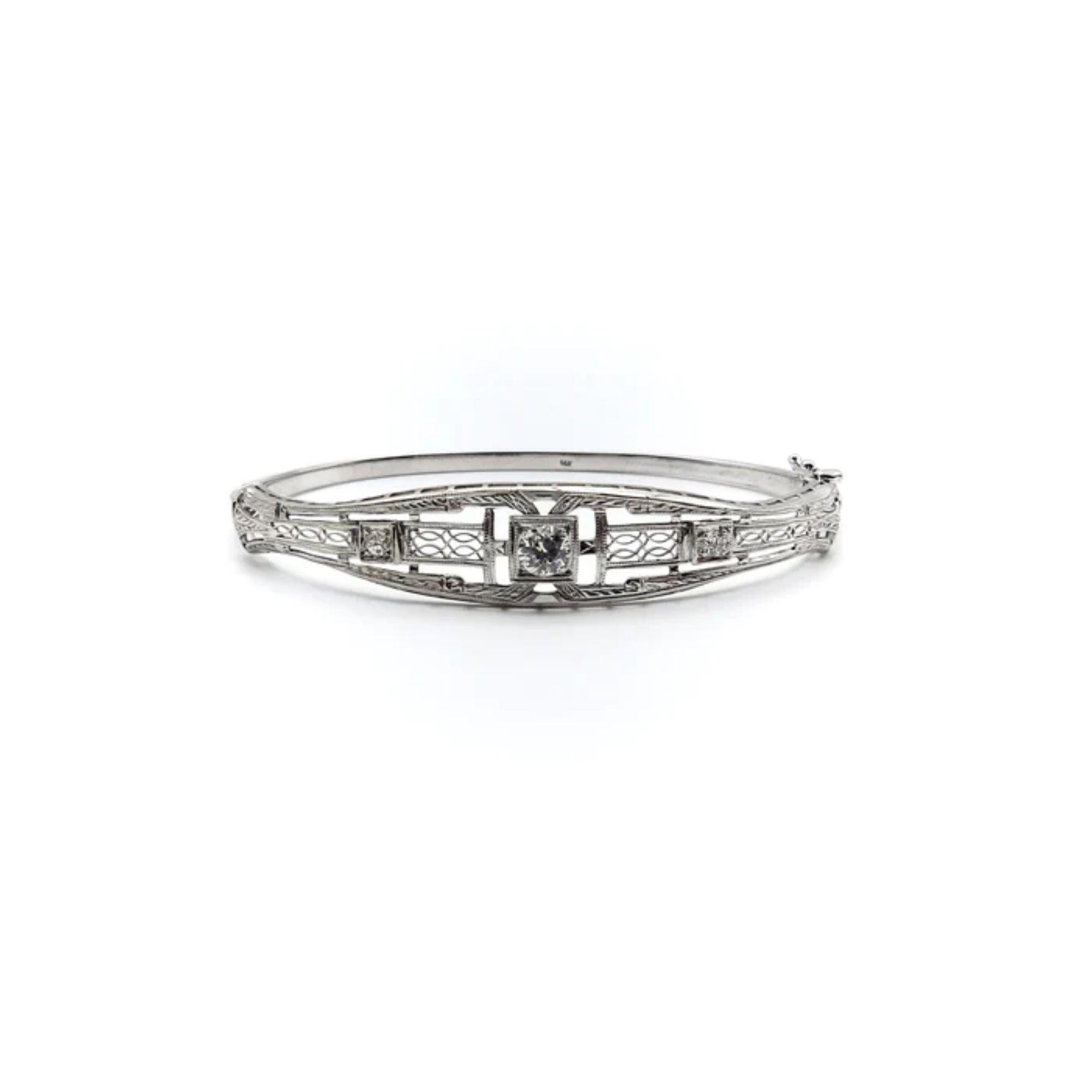 Part of Kirsten’s Corner signature line, this bracelet was converted from a beautiful Art Deco bar pin by carefully bending it to create a bangle. The focal point of the piece is the center stone, a transitional cut round diamond set in a square