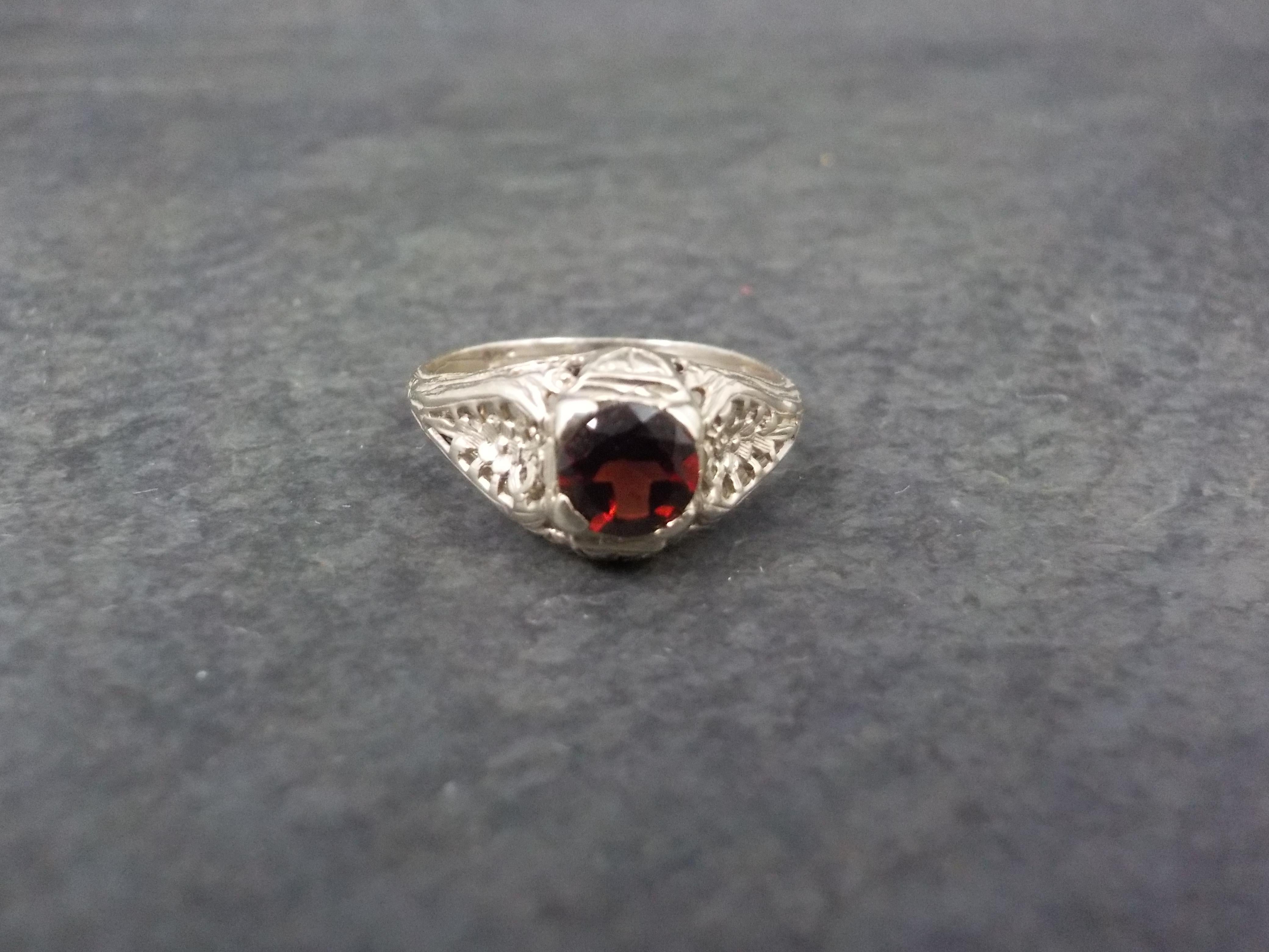 This beautiful vintage ring is 14k white gold. It features a stunning art deco filigree design and a genuine 5mm round garnet gemstone.
The face of this ring measures 5/16 of an inch north to south with a rise of 5mm off the finger.
Size: 5
Marks: