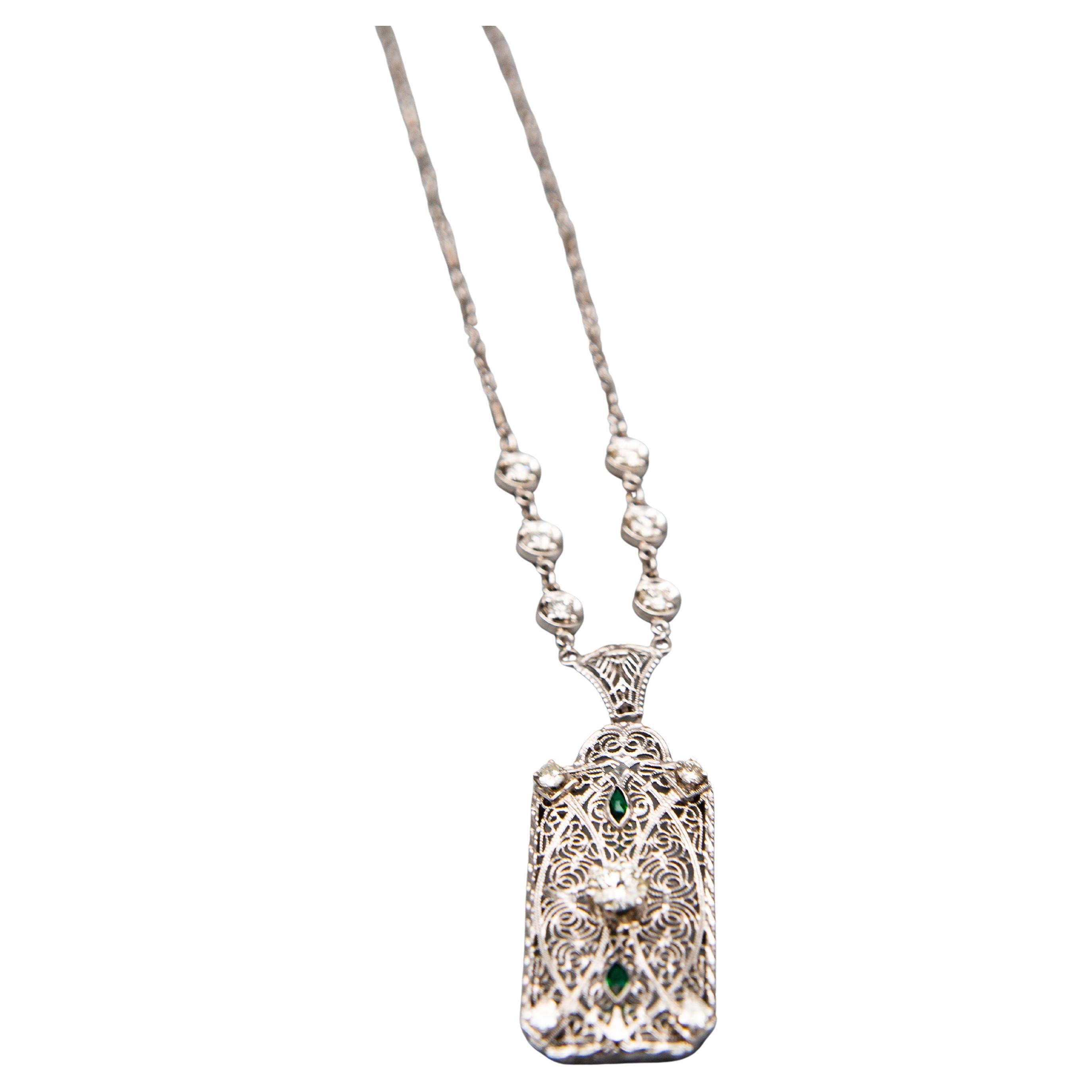 MATERIAL : Or blanc 14k
Poids : 8,3 grammes
Pierre précieuse : Diamant 1.30 cttw
Émeraude 0,12 cttw
Dimensions du pendentif : 49,2 mm avec la bague ; 38,4 mm sans la bague : 18,2 mm de large

Magnifique collier de style Art déco orné de diamants et