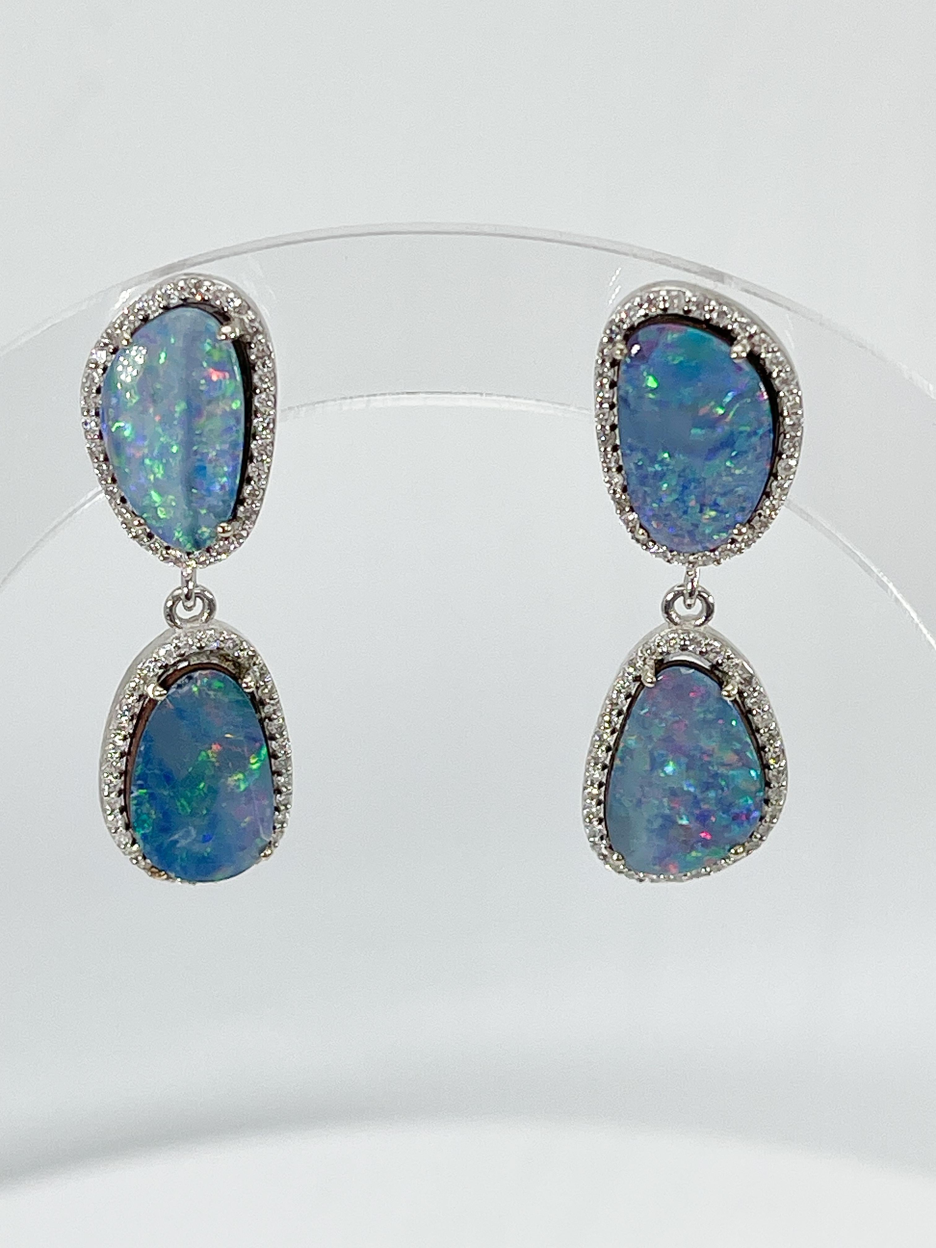 14k white gold Australian opal and .65 CTW diamond earrings. The diamonds in these earrings are all round, the measurements are 35 x 11 mm, and they have a total weight of 6.82 grams.