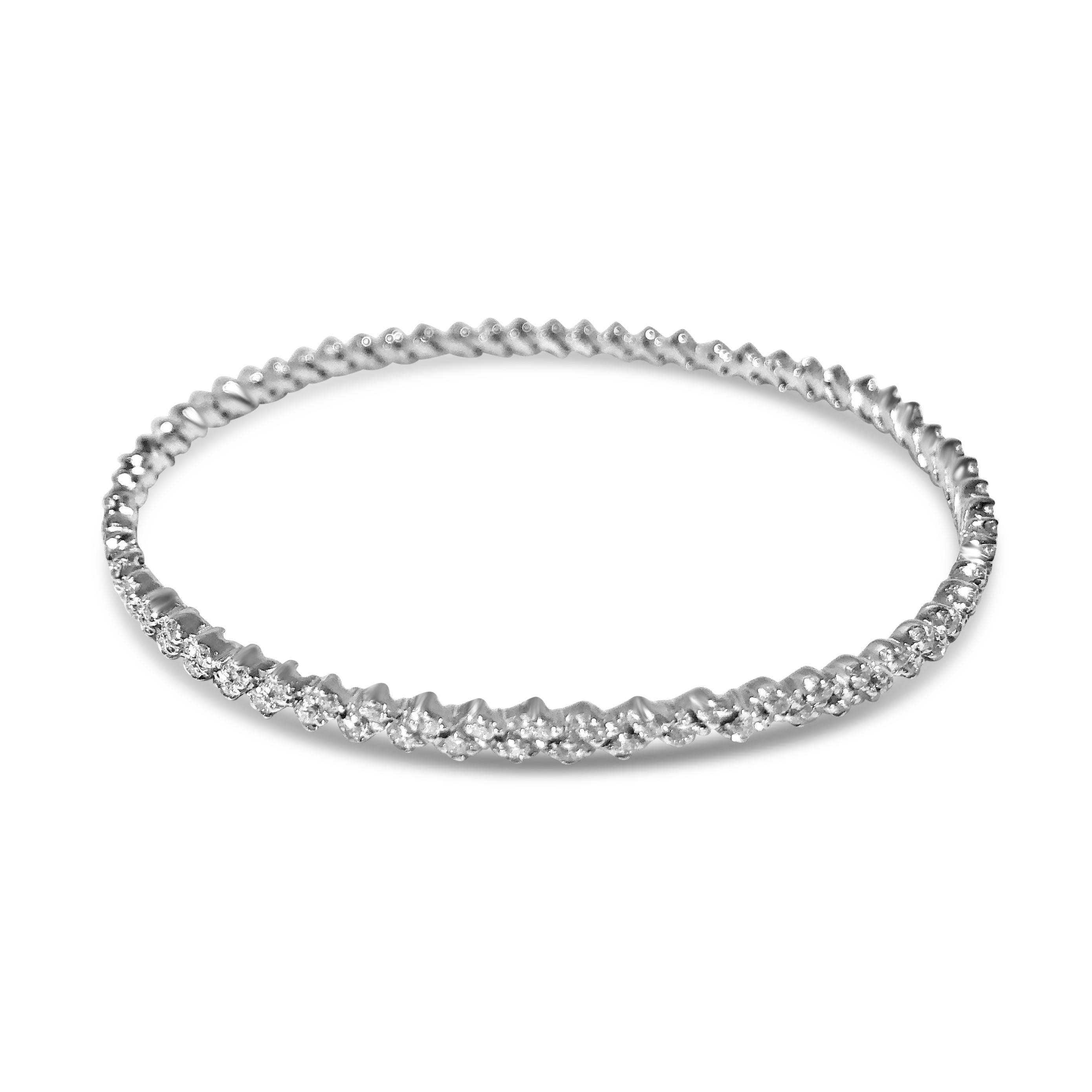 A playful take on a classic diamond bangle featuring a zig-zag chevron diamond pattern. Our round, 14K white gold bangle slips over the wrist and features 126 brilliant round 1.5mm and 1.6mm white diamonds, totaling 2.08ct

Specifications:
-