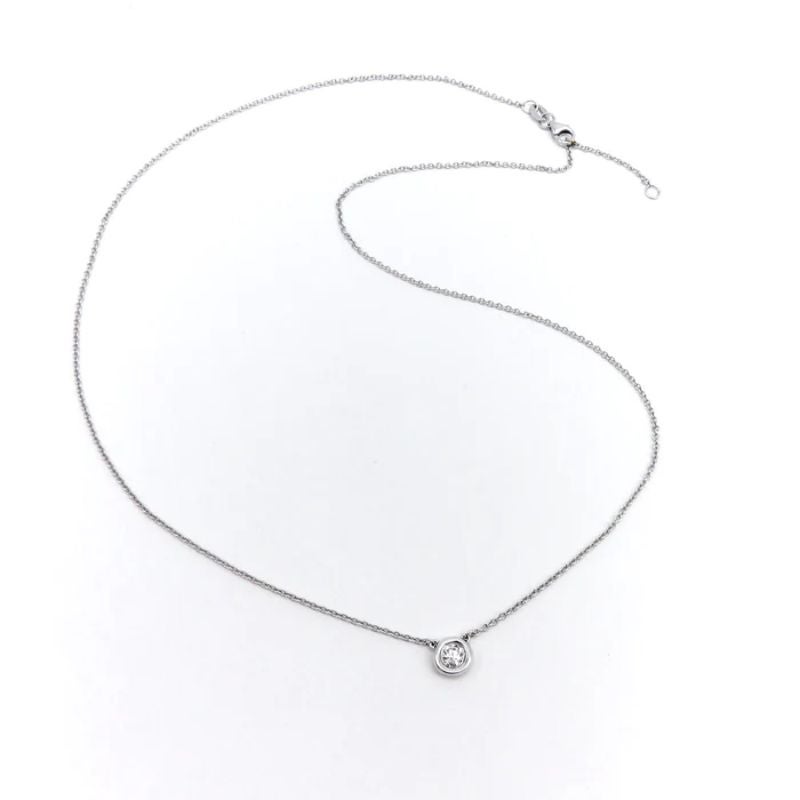 This contemporary necklace features a solitaire diamond set in a round bezel on a delicate 14k white gold chain. The chain length is 18 inches, and can be adjusted to 17 inches, ideal for stacking and layering. The open-back bezel allows for the