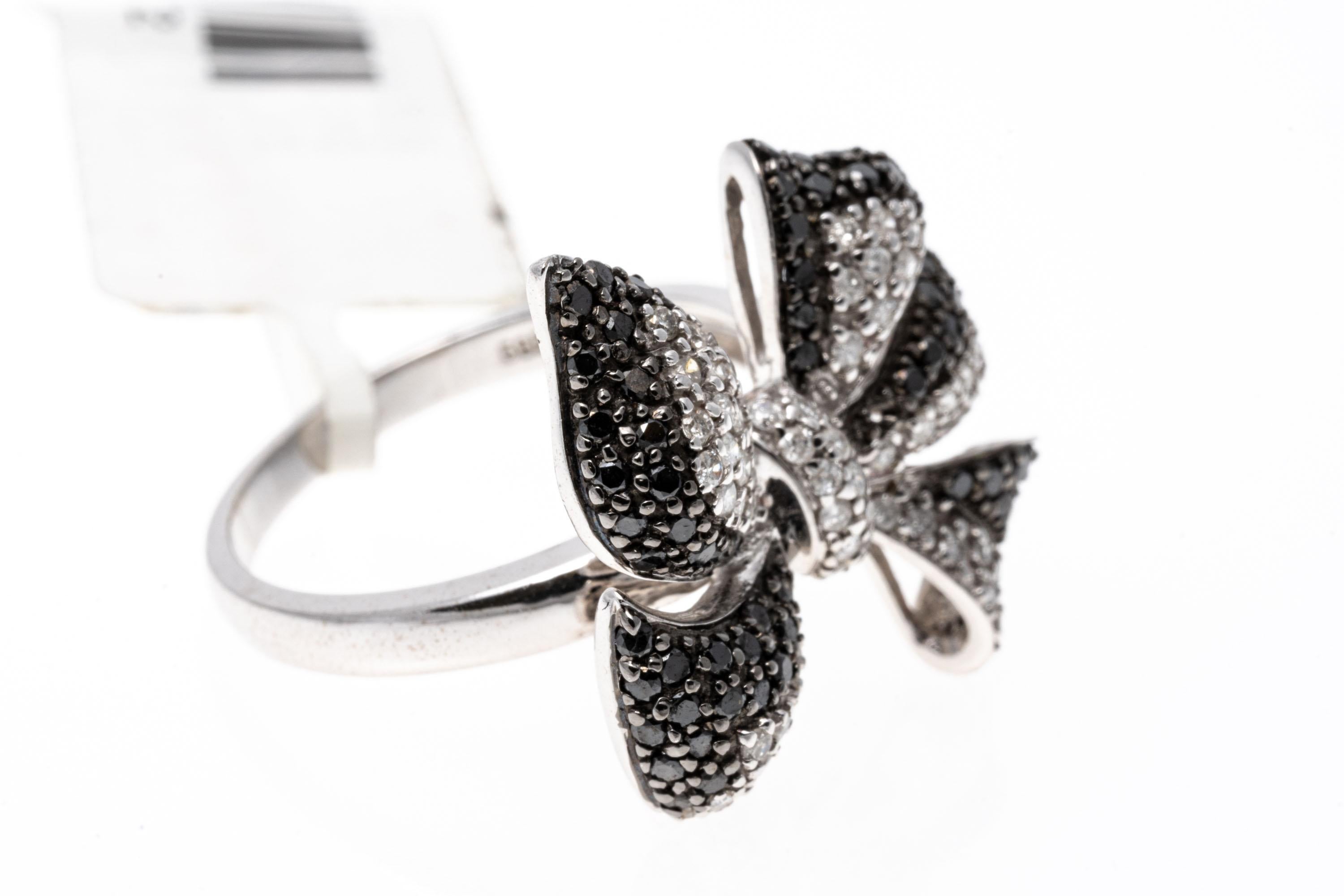 An adorably elegant 14K white gold ring featuring a fanciful bow design set with white diamonds with black diamond trim. Black and white is always a classic! Diamonds approximately 1.0 TCW. Ring size 7.
Marks: 14K 585
Dimensions: 3/4