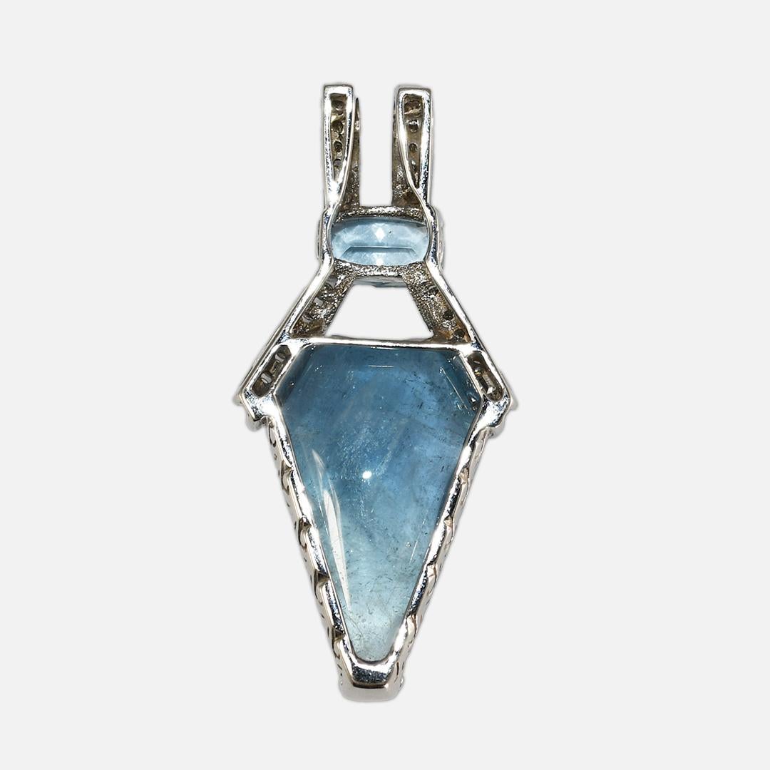 Blue beryl, blue topaz, and diamond pendant in 14k white gold setting.
The setting tests 57% with an XRF analyzer.
The pendant's gross weight is 15 grams.
The large unfaceted blue stone tests beryl on a refractometer.
It has natural inclusions in