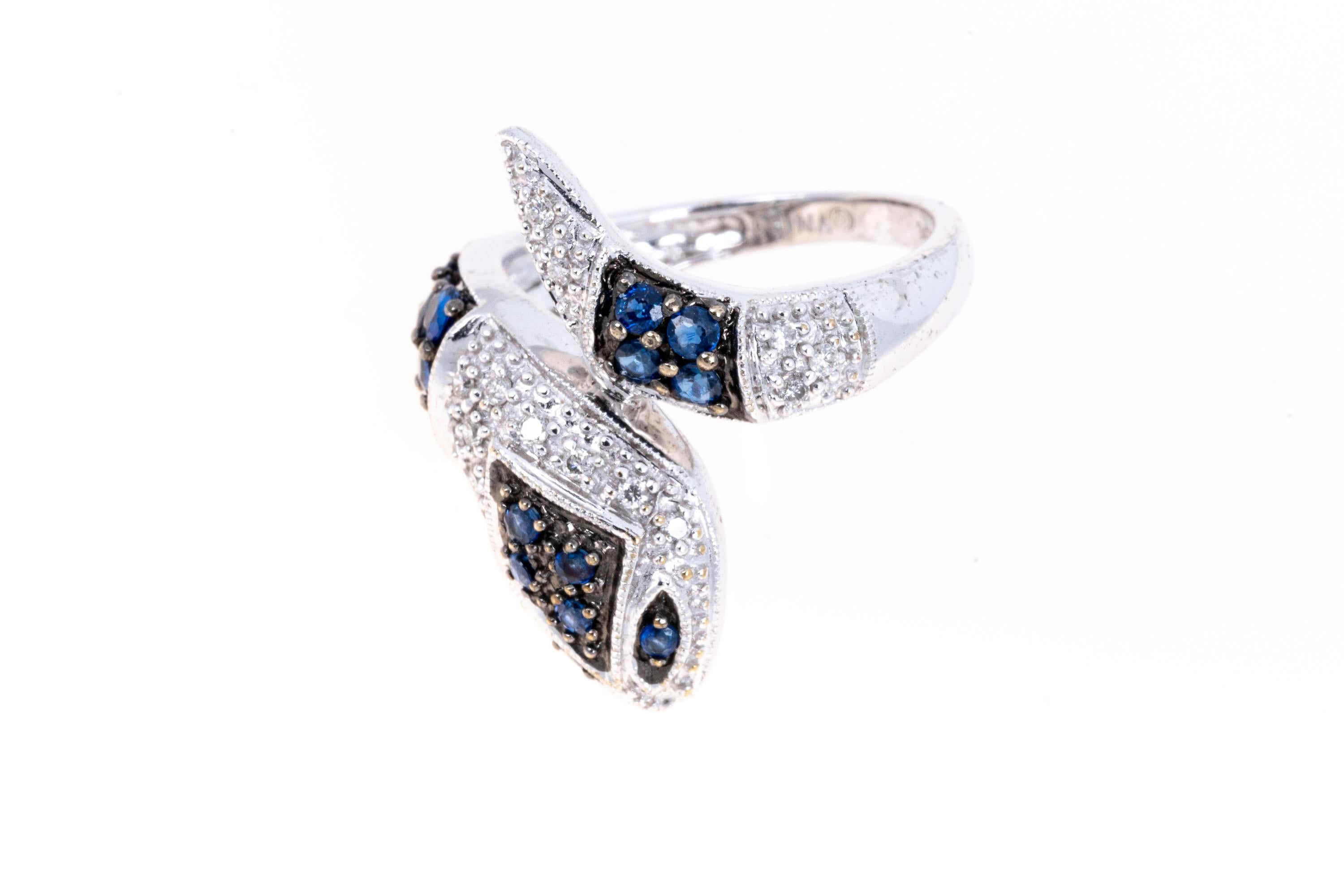 14k white gold snake ring. This charming snake is an alternating combination of prong set round diamonds (approximately 0.09 TCW) and round medium blue sapphires, approximately 0.60 TCW, coiled in a bypass style motif
Marks: 14k
Dimensions: 3/4