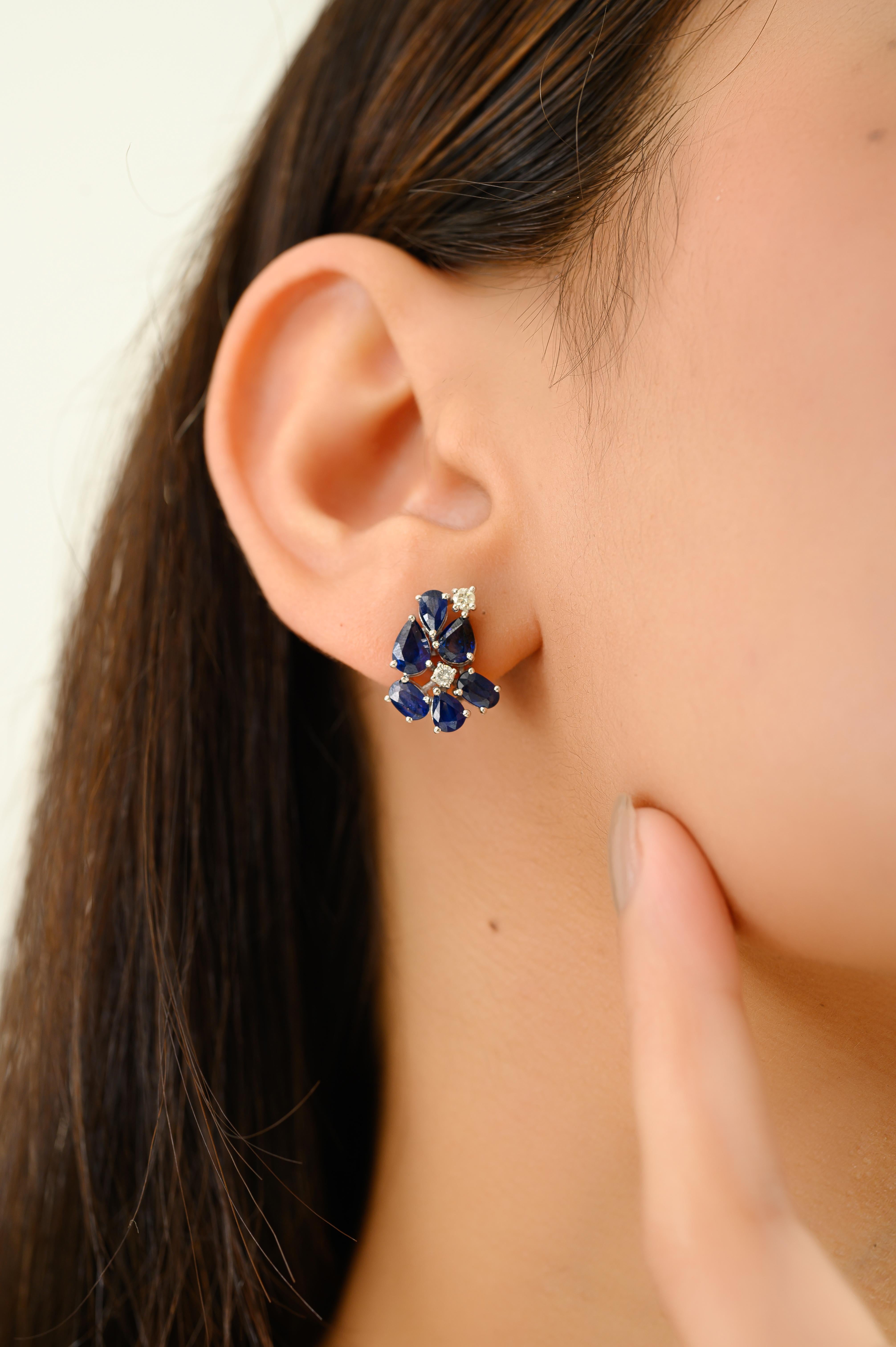 Crafted in radiant 14k white gold, these elegant cluster earrings showcase a floral-inspired design set with 4.09 carats of richly hued blue sapphires. The pear and oval-shaped sapphires are arranged in a graceful bloom, accented by 0.20 carats of