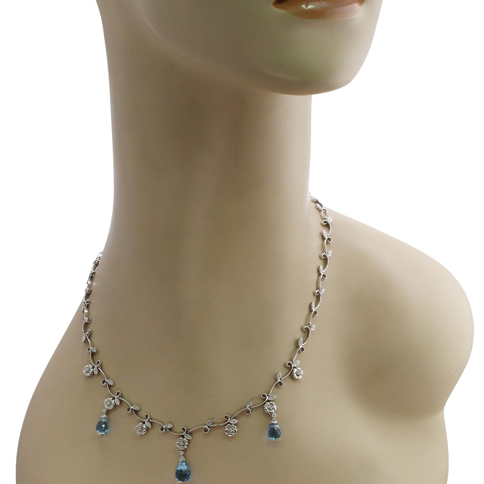 This gorgeous garland necklace features a design of leaves and flowers crafted in 14k white gold and accented with blue topaz briolletes and 30 round diamonds weighing an estimated 0.25 - 0.30 carats. Made in United States circa 1990s. Measurements: