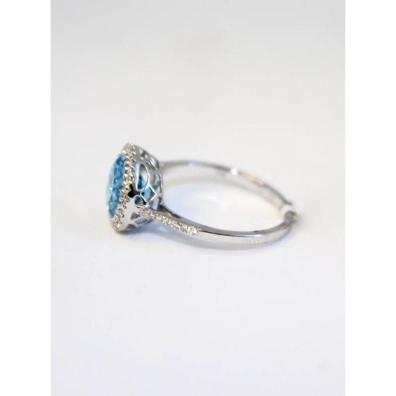 Wow! This stunning blue topaz ring is set in 14K White Gold with One (1) Round Blue Topaz weighing 2.51ctw and is surrounding by a Round Diamond Halo and Diamonds down the sides all weighing 0.21ctw. It is currently at a sized 7 but can be resized