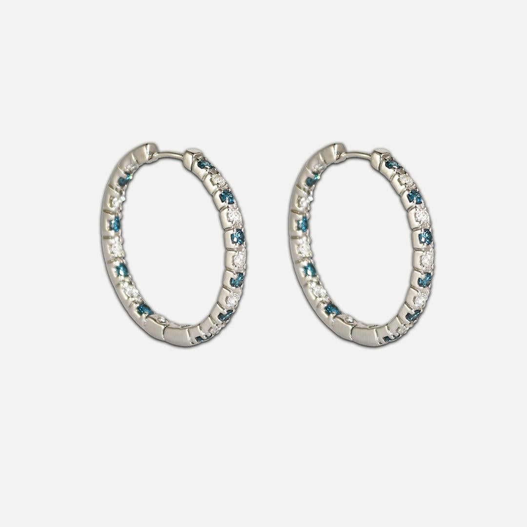 Ladies 14k white gold and diamond hoop earrings.
The earrings test 14k and weigh 9.3 grams.
There heated treated blue diamonds in between the white diamonds.
The white diamonds are round brilliant cuts, h, i, and j color range, Si to i1 clarity, and