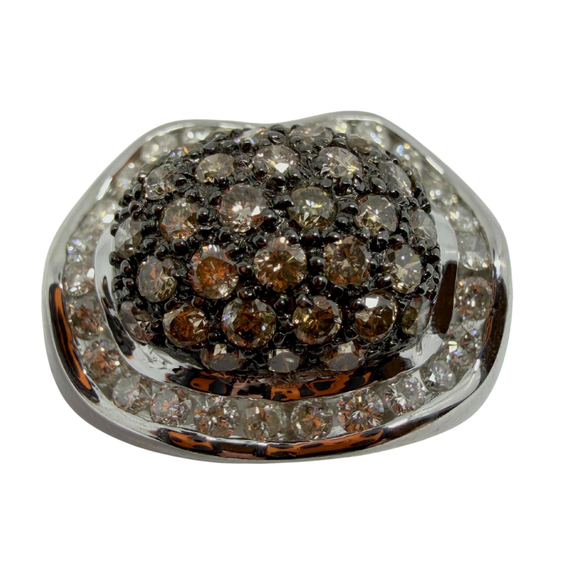Cette bague dôme audacieuse présente un mélange saisissant de diamants bruns et blancs qui captent la lumière sous tous les angles. Avec ses tons neutres, il s'adapte à toutes les tenues, qu'elles soient décontractées ou de soirée, et ajoute une