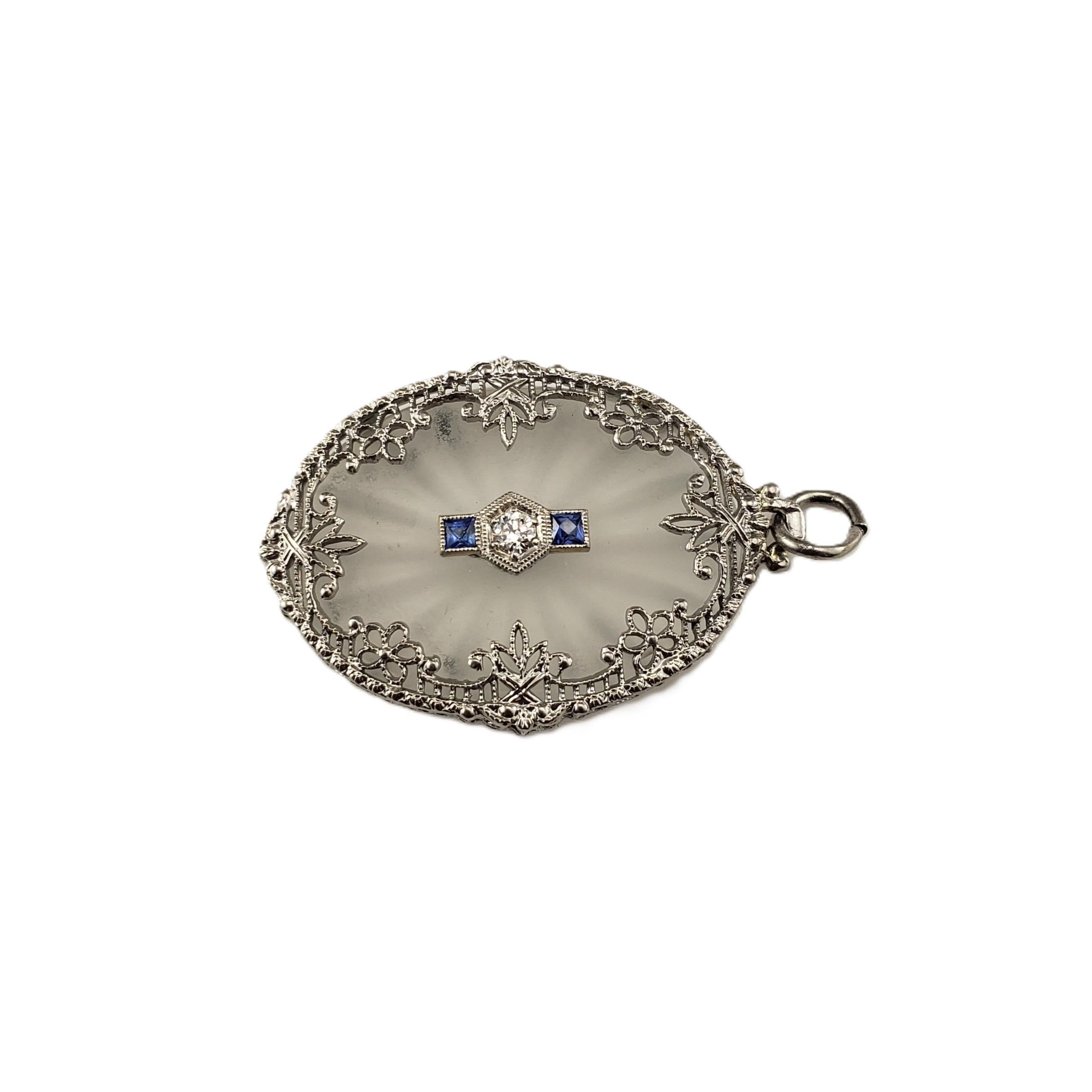 14 Karat White Gold Camphor Glass and Diamond Pendant-

A beautiful example of Art Deco jewelry, this pendant showcases a frosted camphor glass centerpiece framed in a delicate 14K white gold floral filigree border. At its heart, a sparkling round