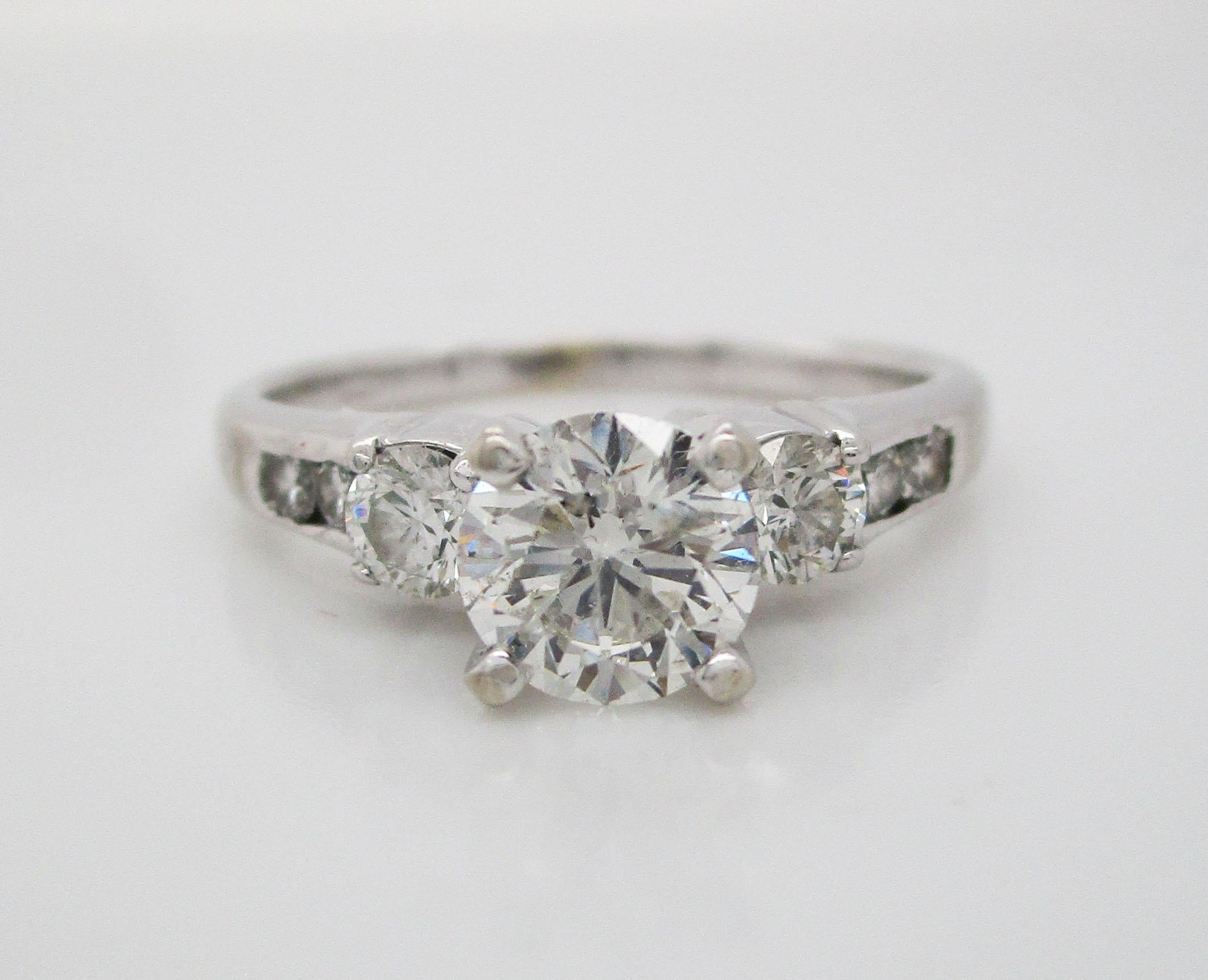 This stunning engagement ring is in 14k white gold and boasts a certified 0.78 carat diamond center! The diamond center is accented by three diamonds on each side, creating a gorgeous, glittering ring! This is the perfect ring for the woman who