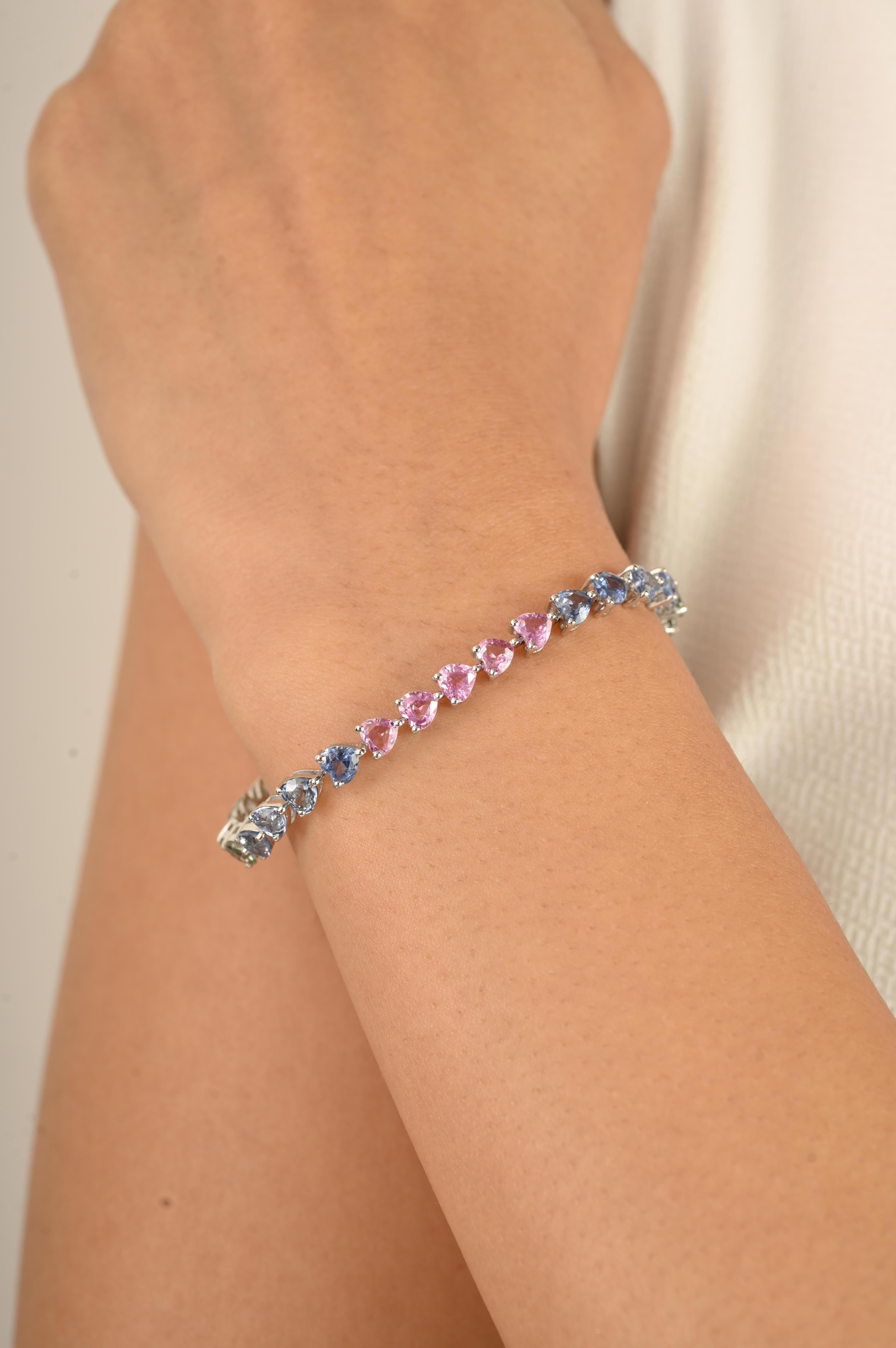 Celebra il colore, l'eleganza e l'artigianato senza tempo con questo squisito bracciale tennis in oro bianco 14 carati. Con ben 11,33 carati di zaffiri multipli a forma di cuore, ogni pietra è meticolosamente incastonata per creare un armonioso