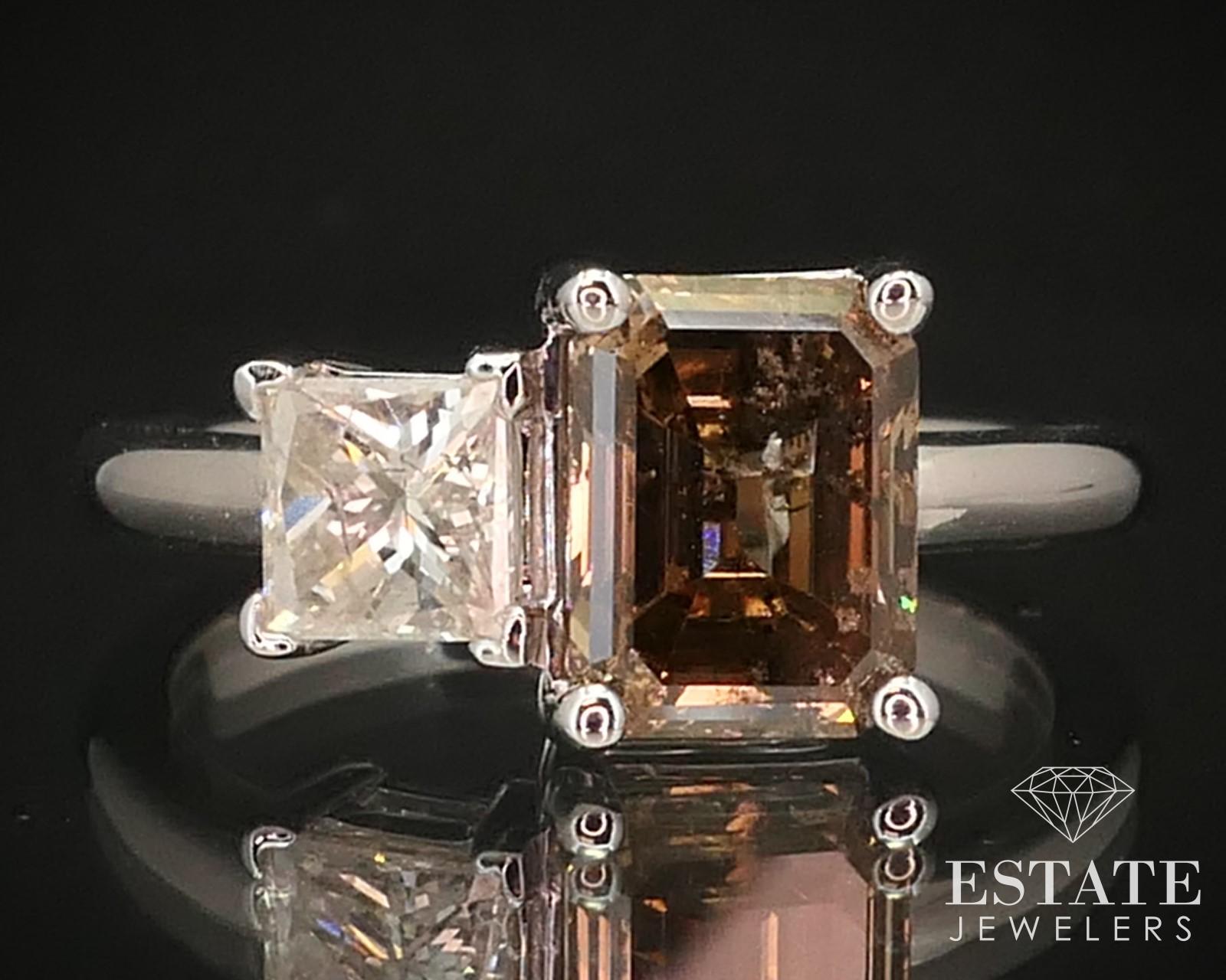 Beautiful custom made band with a 2.02ct emerald cut champagne diamond on one side and a .58ct princess cut white diamond next to it. Unique and stunning combo of diamonds! I1 clarity with K color to the white diamond. 8.2mm by 6.3mm emerald cut