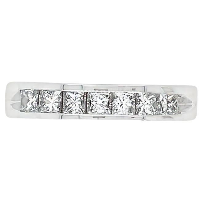 This is a stunning wedding band made of 14K white gold. It features seven (7) princess cut diamonds weighing a total of 0.84 carat. The diamonds are set in a channel on the front half of the ring, adding a modern and dazzling touch. The diamonds are