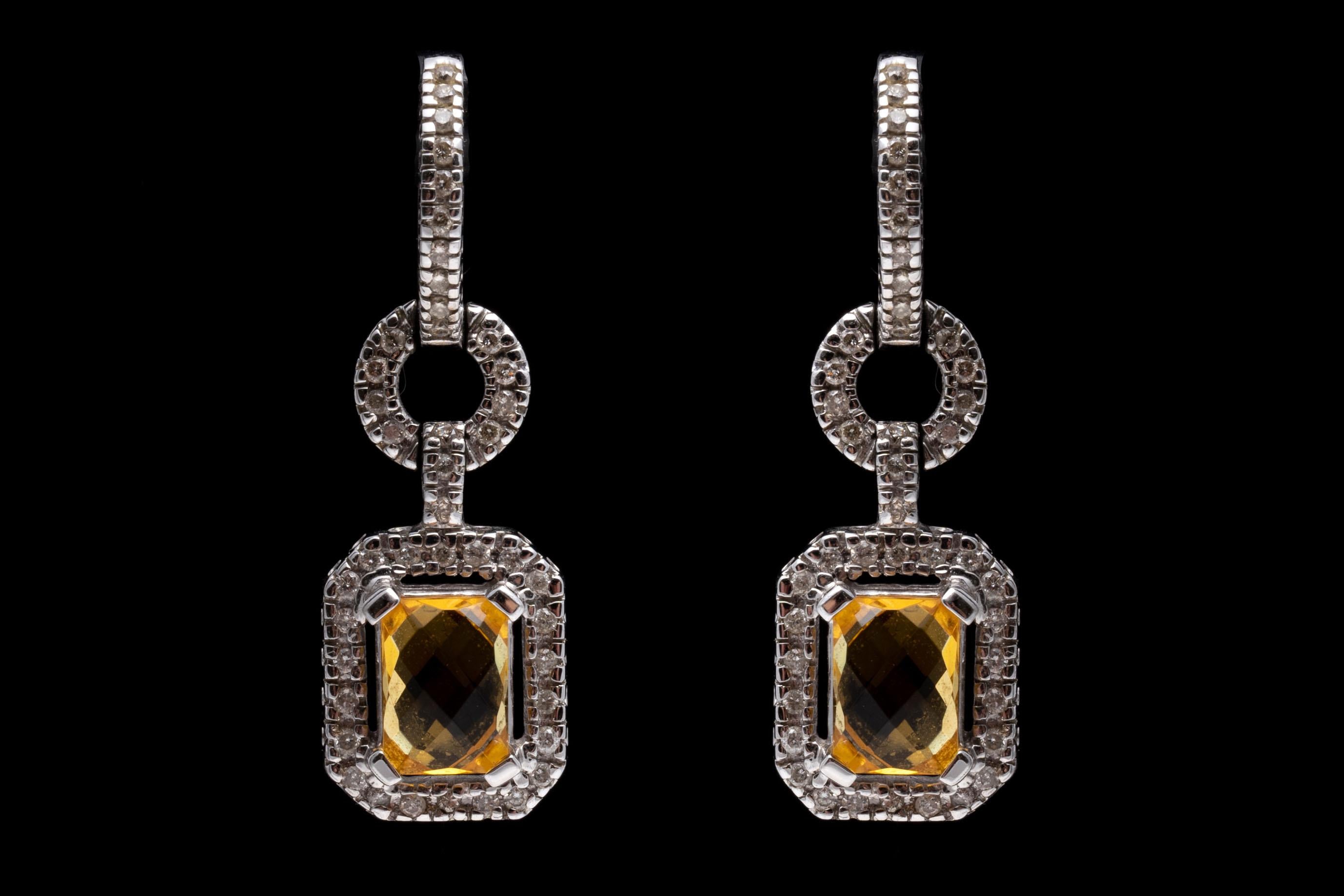 14K White Gold, Citrine And Diamond Dangle Earrings
14K white gold dangle earrings set with rectangular cut citrines displaying a light pineapple yellow. Framing the citrines are round cut diamonds. Citrines are approximately 1.45 TCW and the