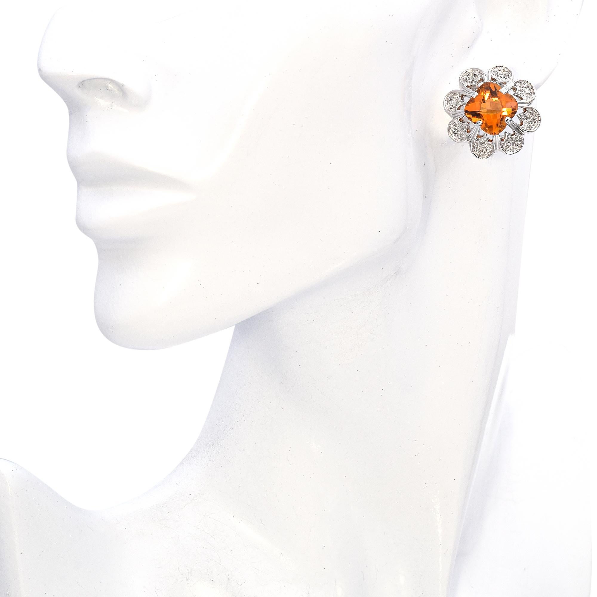 Un elegante paio di orecchini floreali. Realizzati con precisione, questi orecchini presentano un sorprendente citrino arancione al centro, sfaccettato a scacchiera. Intorno alla gemma centrale ci sono dei disegni a forma di petali incrostati di