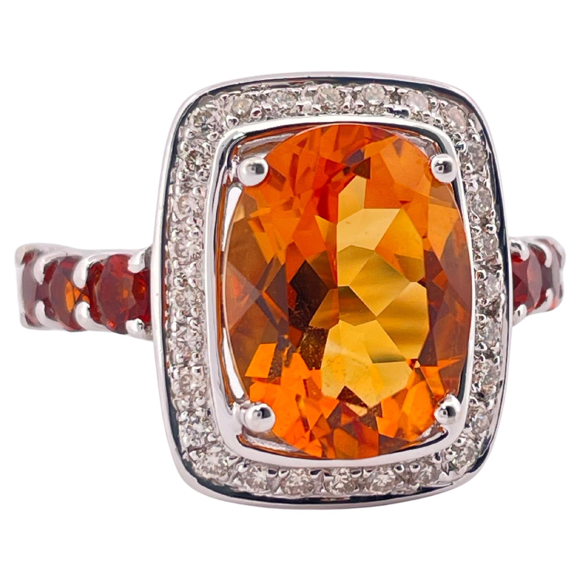 Dieser exquisite Ring aus 14-karätigem Weißgold zeigt einen lebhaften Citrin im Kissenschliff, der einen fesselnden gold-orangenen Glanz ausstrahlt. Den Mittelstein umgibt ein Halo aus funkelnden runden Diamanten von insgesamt ca. 0,42 Karat, der