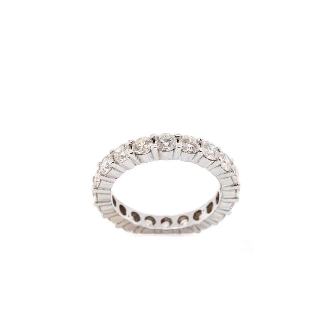 One lady's custom made polished rhodium plated 14K white gold, diamond eternity band. The band is a size 7 and measures approximately 3.40mm in diameter and weighs a total of 3.40 grams. In excellent condition.

Shared-Prong Set in 14 Karat White