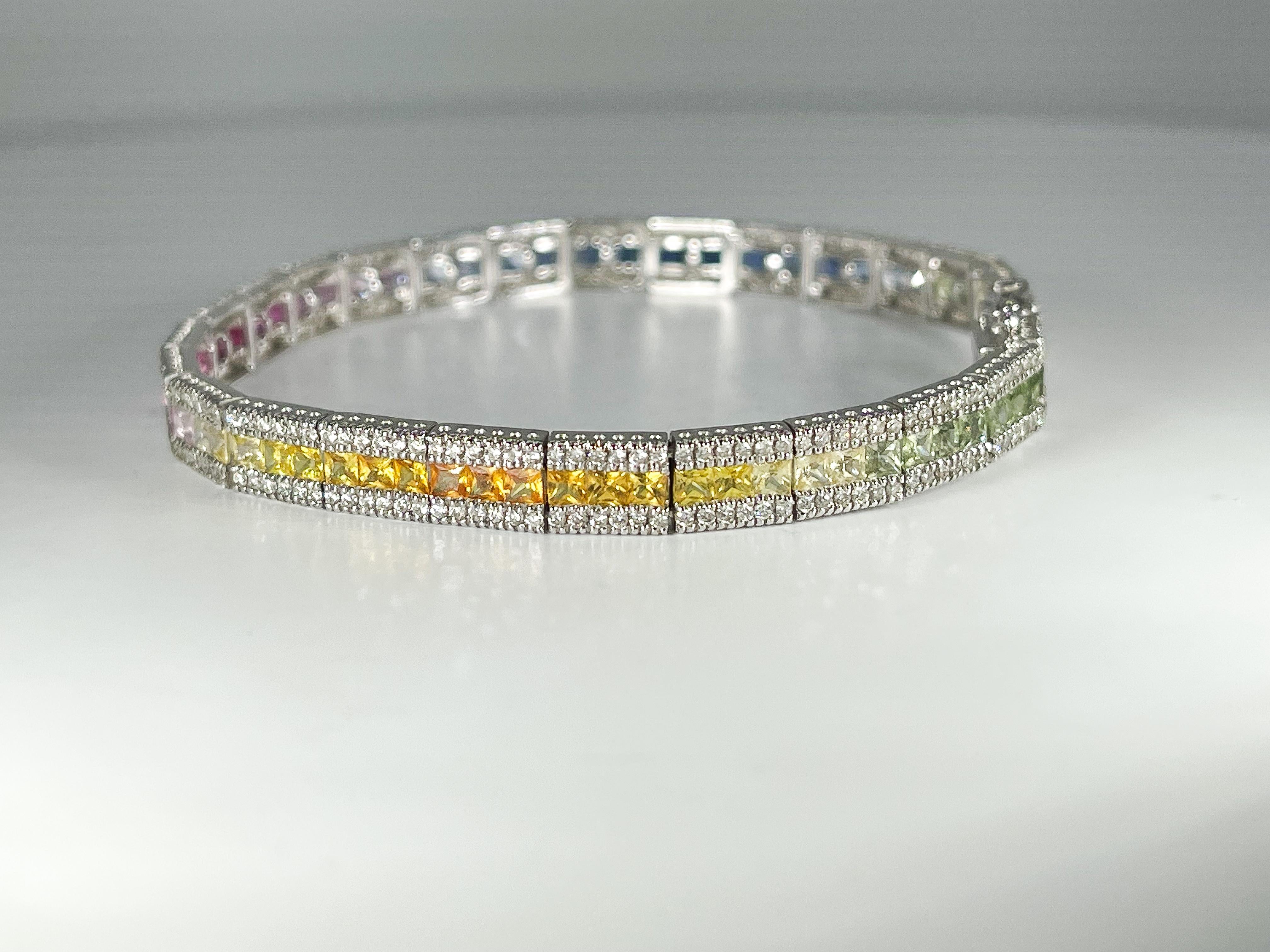 14k white gold fashion bracelet with colored princess cut sapphires and round diamonds. The sapphires are placed in a gradient fashion to show each color spectrum of the rainbow and the diamonds are placed alongside the sapphires for an enhanced