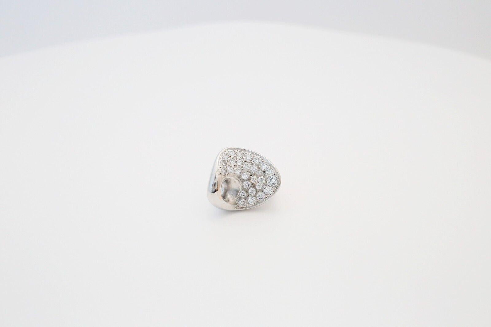 This striking 14k white gold ring blends contemporary design with luxurious elegance. The band features a bold, asymmetrical silhouette with a smooth, highly polished finish that contrasts beautifully against a field of pavé-set diamonds. The