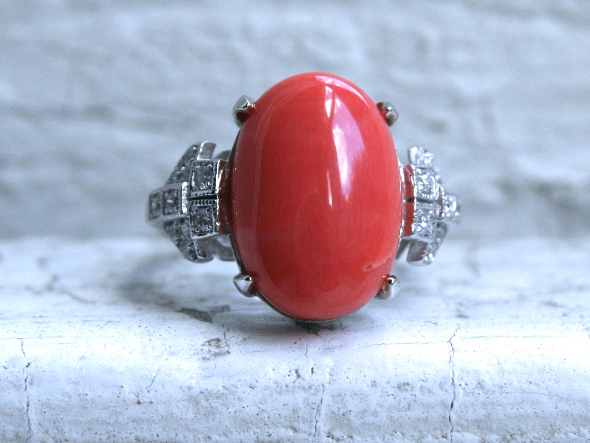 Gorgeous!! This Vintage 14K White Gold Coral and Diamond Buckle Ring Engagement Ring has an amazing pop of color, and great design. Crafted in 14K White Gold, this ring features a the beautiful coral center, beaded edges, and of course, the Art Deco