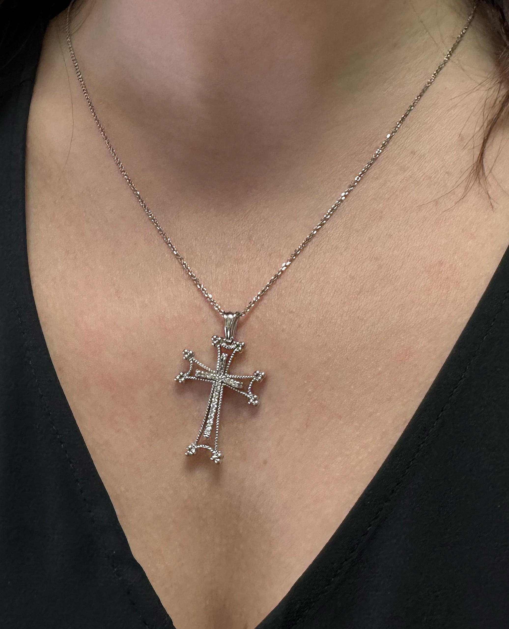 Pendentif croix en or blanc 14K avec 24 diamants ronds pesant 0,18 carat au total.  La croix se glisse sur une chaîne en or blanc de 18 pouces pesant 2,8 grammes.