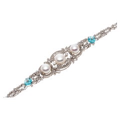 Bracelet néo-baroque en or blanc 14 carats, perles et diamants avec fleur de topaze bleue