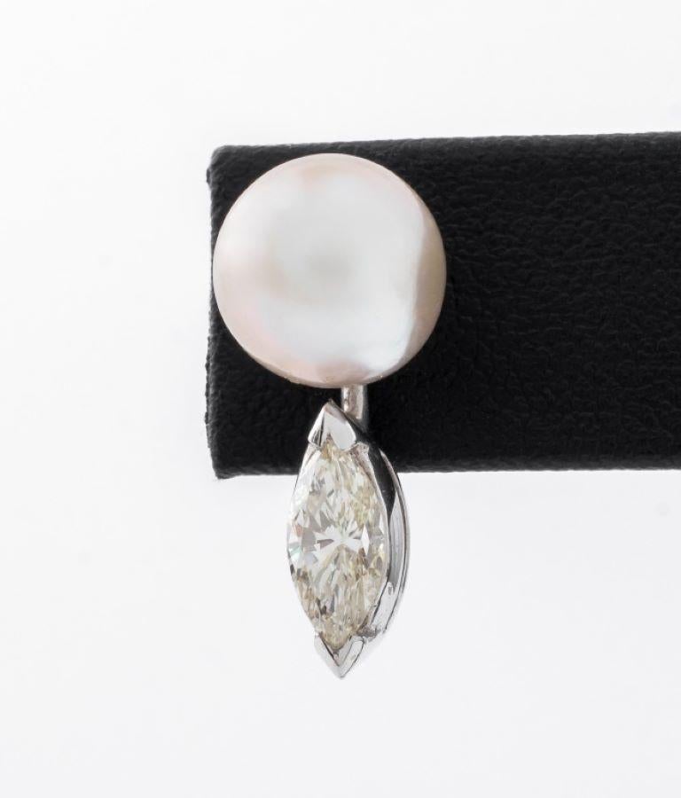 14K white gold earrings, brightly polished, featuring two round cultured pearls, approx. 9.0 - 9.5 mm, further adorned with two prong set marquise brilliant diamonds, SI2-I1 clarity, J-L color, weighing a total of approx. 0.95 carats, worn through