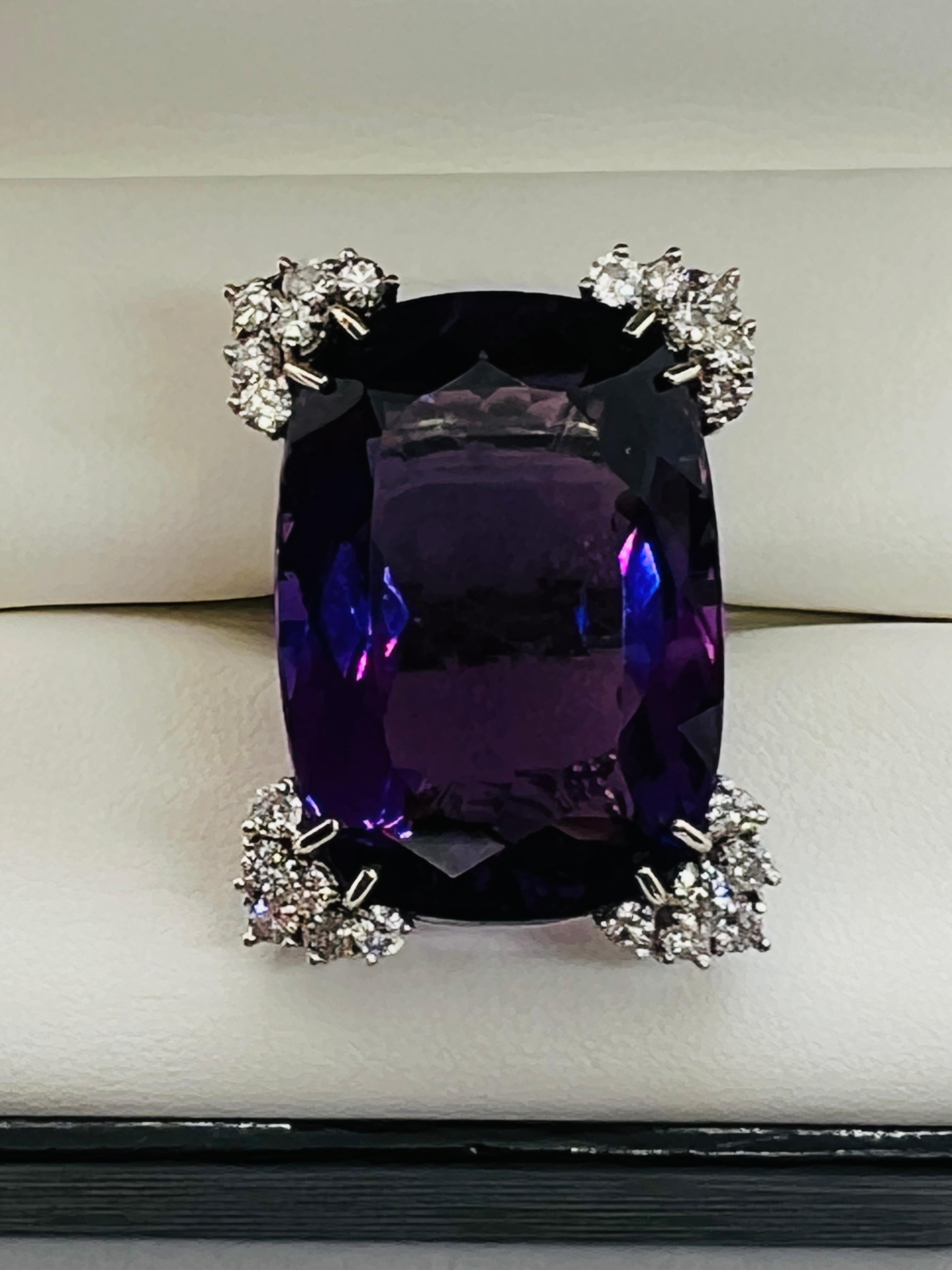 Stunning White Gold Ladies Cocktail Ring! At the center is a cushion cut, 44 carat amethyst that measures 1.25 inches by .75 inch. On each corner of the stone, the prongs are set with 6 round diamonds each. The total number of diamonds is 24 with an