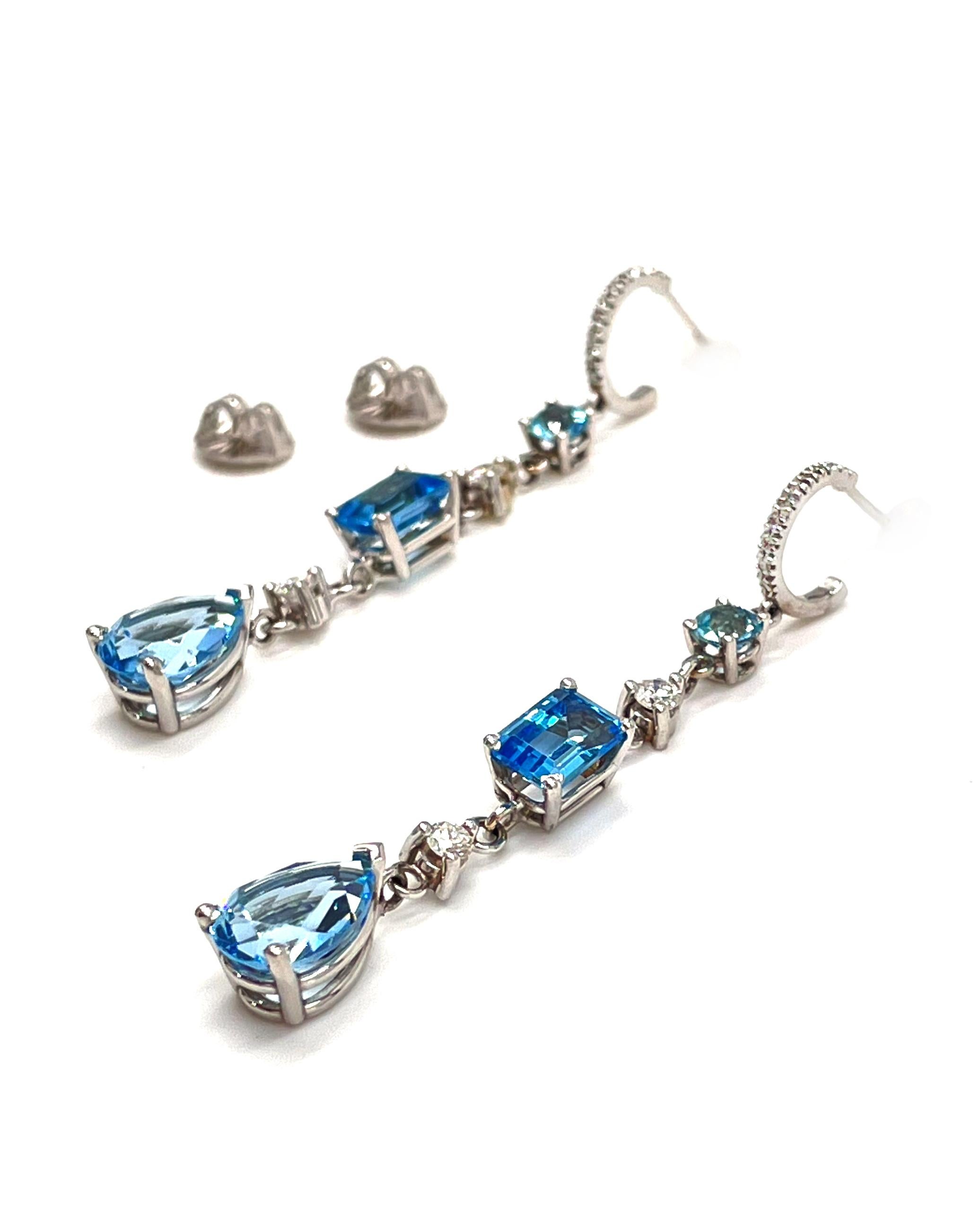 Pair of 14K white gold long dangling earrings with round brilliant-cut diamonds weighing 0.20 carats total and 6 fancy shaped blue topaz weighing 6.91 carats total weight.

- Blue topaz stones are round, emerald cut and pear shaped.
- Friction backs