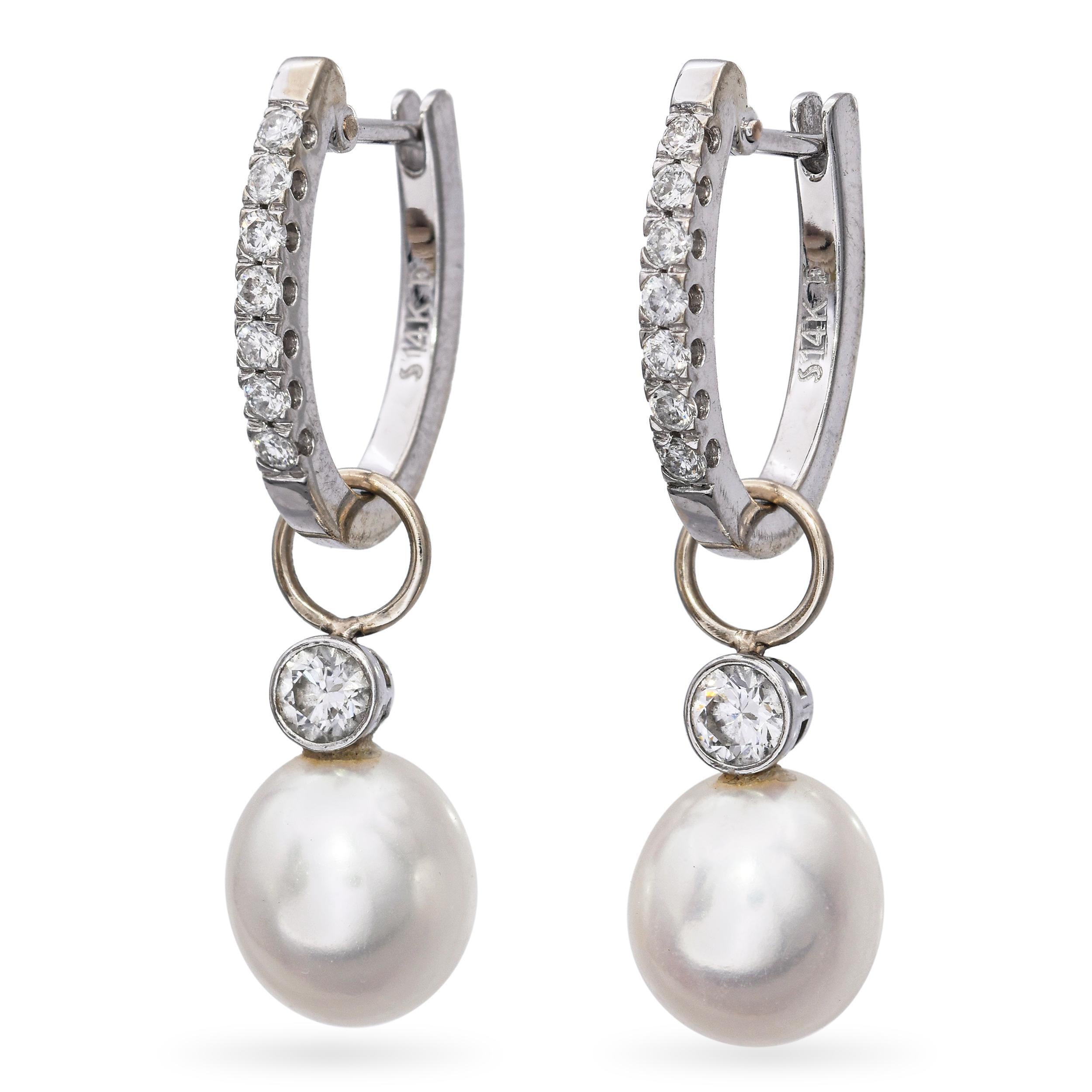 Réalisées en or blanc 14 carats, ces boucles d'oreilles pendantes offrent un mélange raffiné de design classique et contemporain. Les anneaux sont bordés de 0,25 carats de diamants scintillants qui captent la lumière à chaque tour. D'élégantes