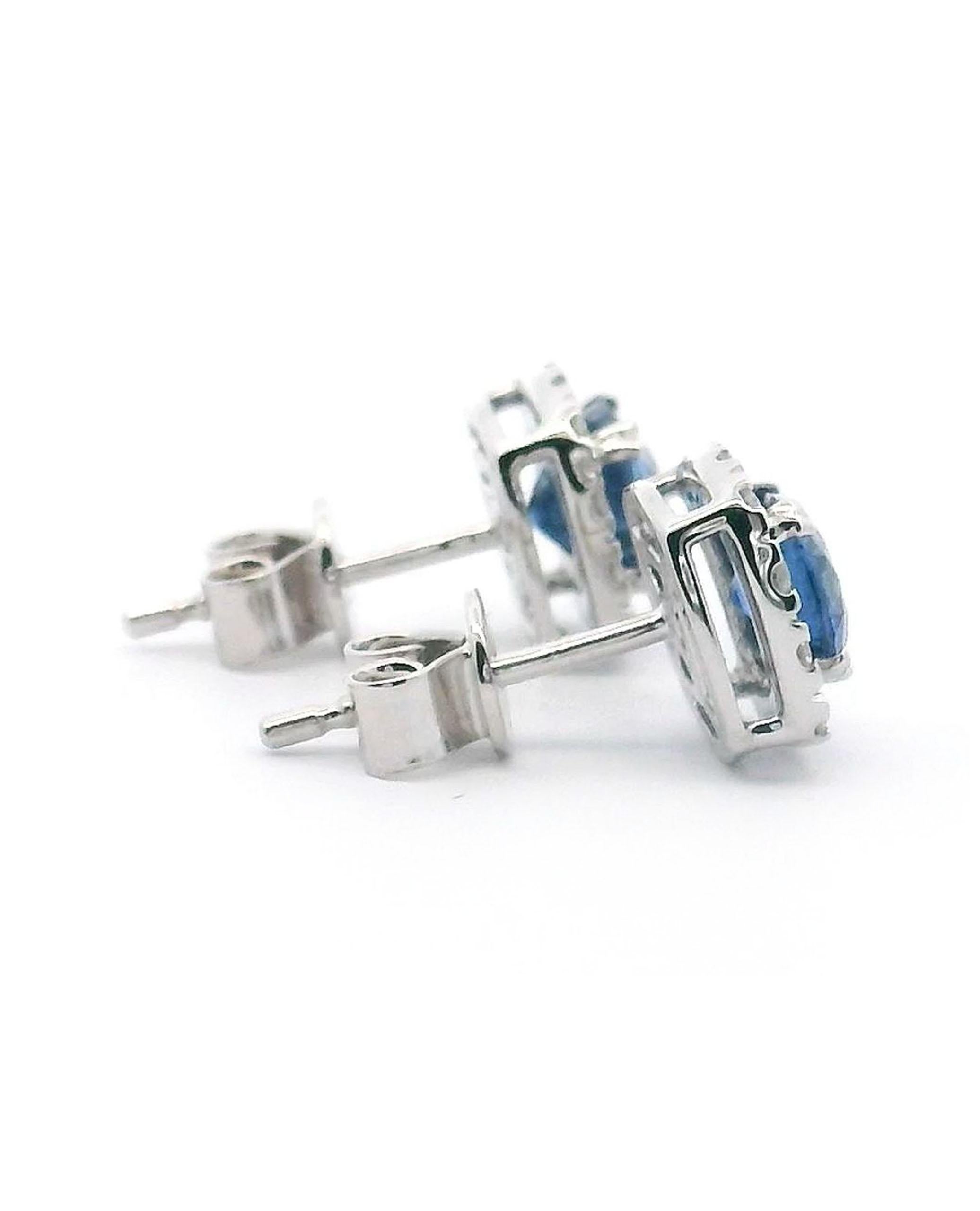 Ohrstecker im Halo-Stil aus 14 Karat Weißgold mit zwei kissenförmigen blauen Saphiren mit einem Gesamtgewicht von 1,55 Karat und runden Diamanten im Brillantschliff mit einem Gesamtgewicht von 0,32 Karat.

- Diamanten sind H Farbe, SI Klarheit
-